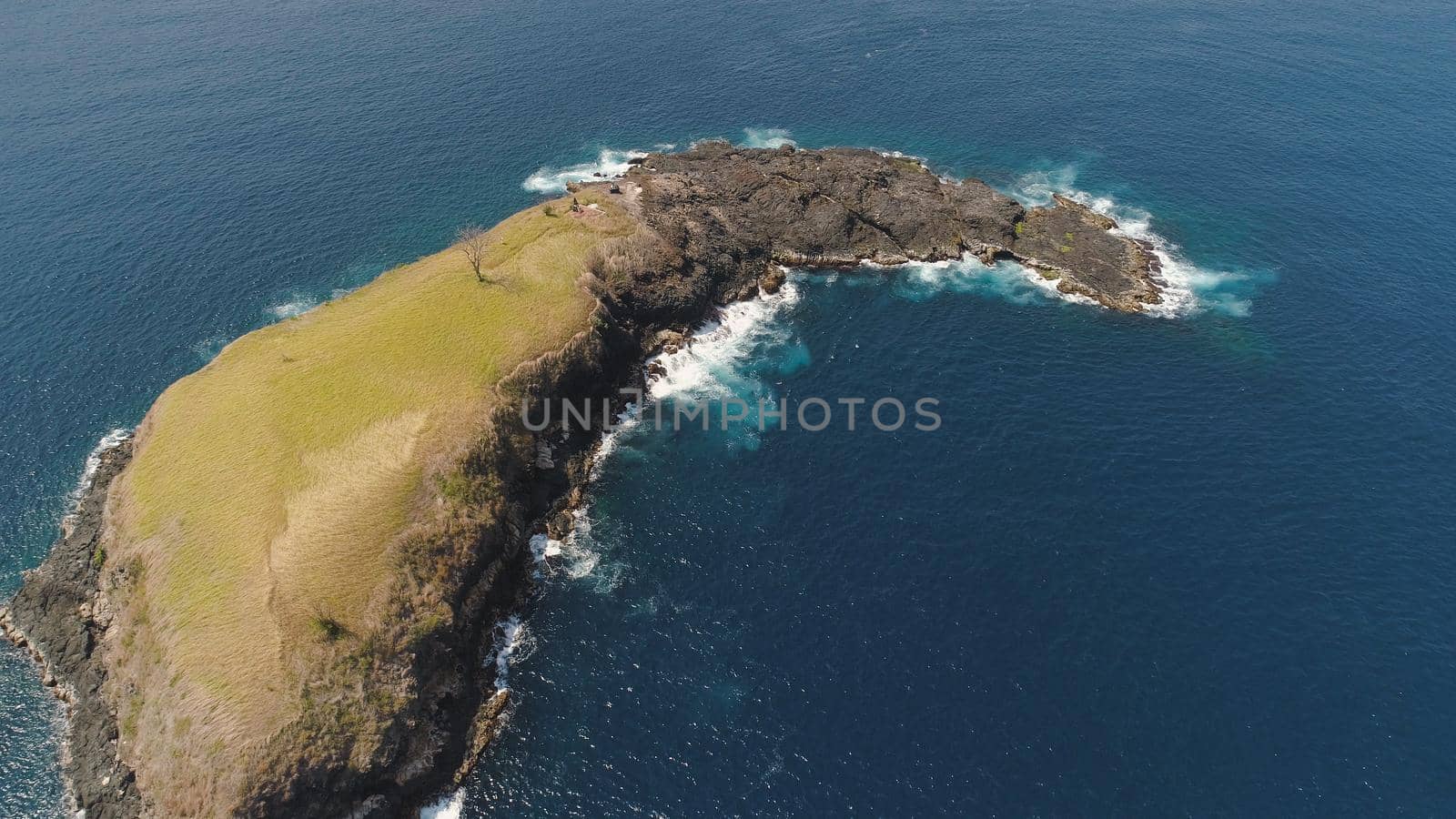 Lonely rocky island in the sea. Aerial view Uninhabited tropical island among the ocean. Travel concept.