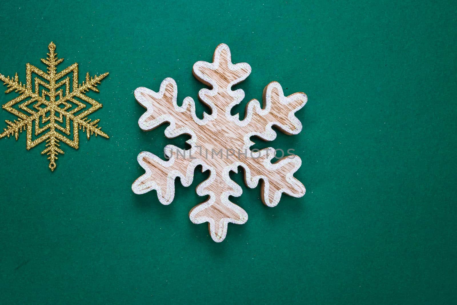 Snowflakes Christmas decoration on green background. Top view with copy space for december season.