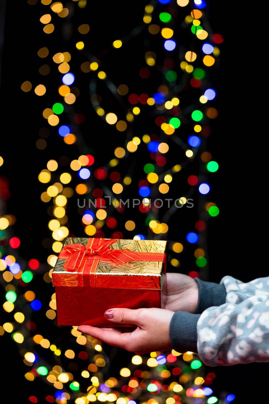 Woman's hands hold christmas decoration. Christmas and New Year holidays background, winter season with Christmas ornaments and blurred lights