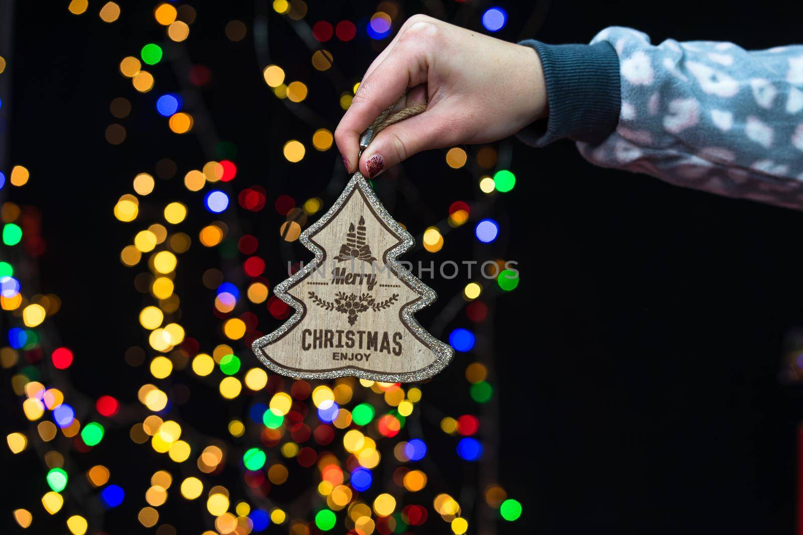 Woman's hands hold christmas decoration. Christmas and New Year holidays background, winter season with Christmas ornaments and blurred lights