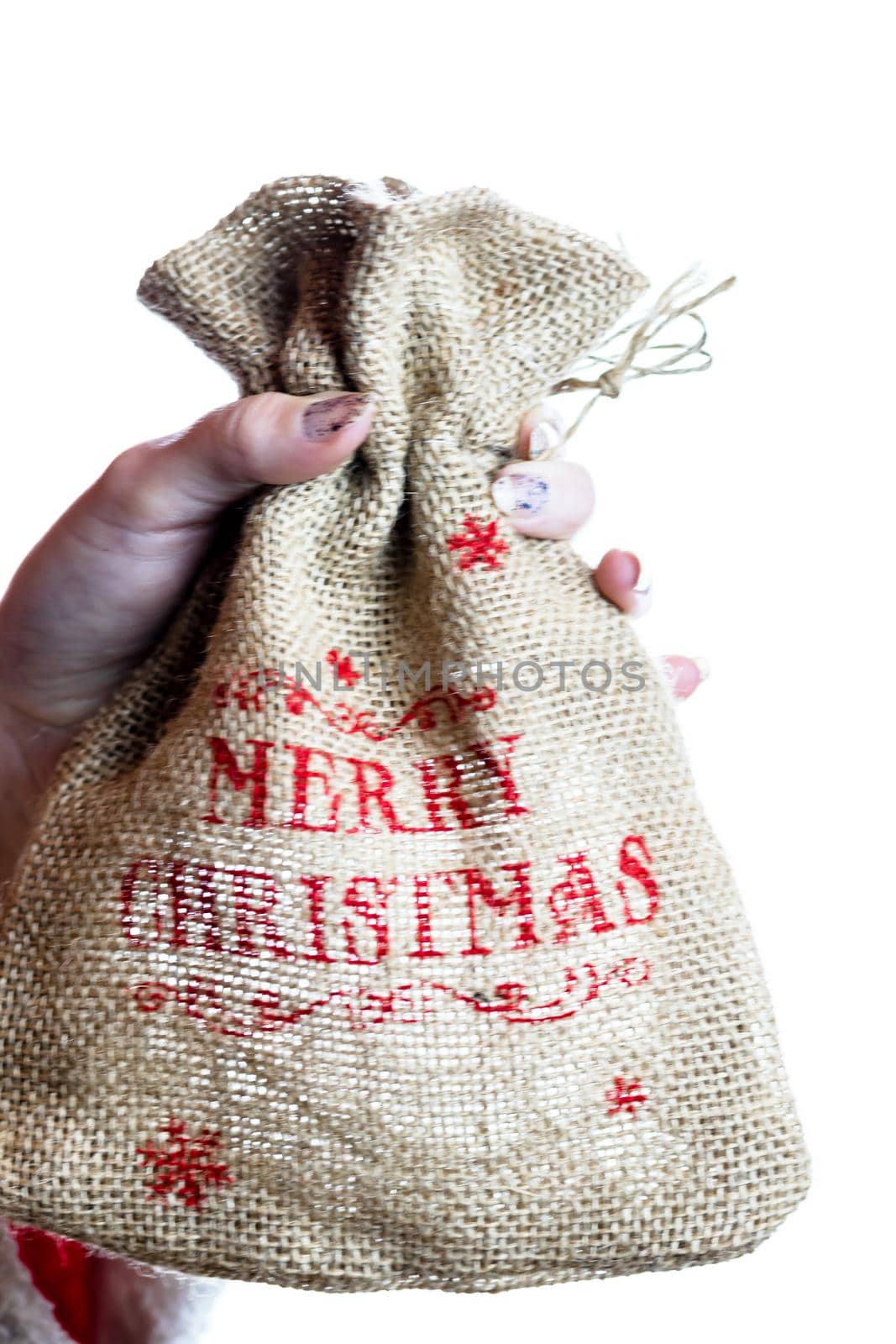 Hand holding Christmas burlap sack isolated on white background