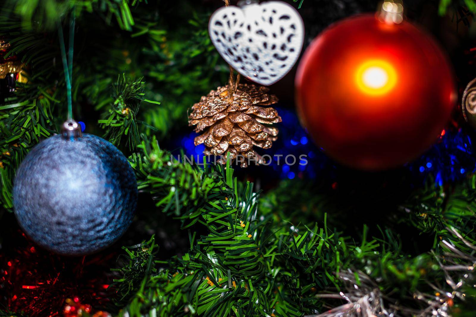 Christmas hanging decorations on fir tree. Decorated Christmas tree. Fir branch with Christmas baubles decorations.