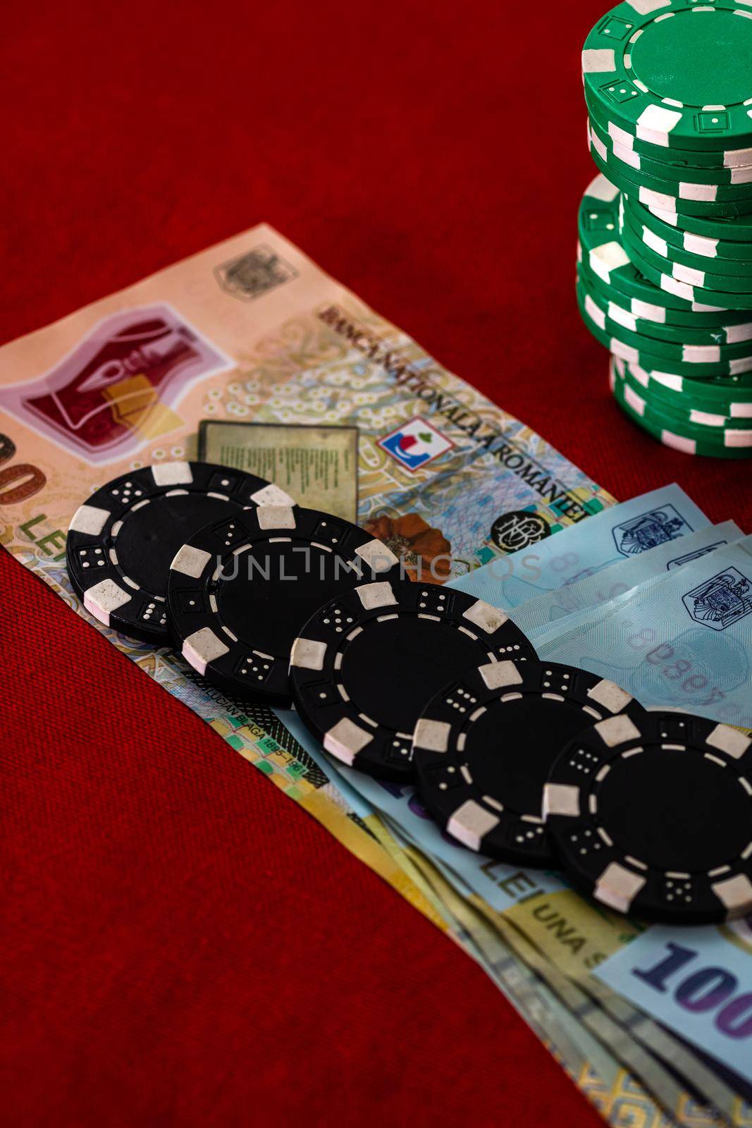 Stacks of poker chips with money on red background, Romanian LEI currency by vladispas