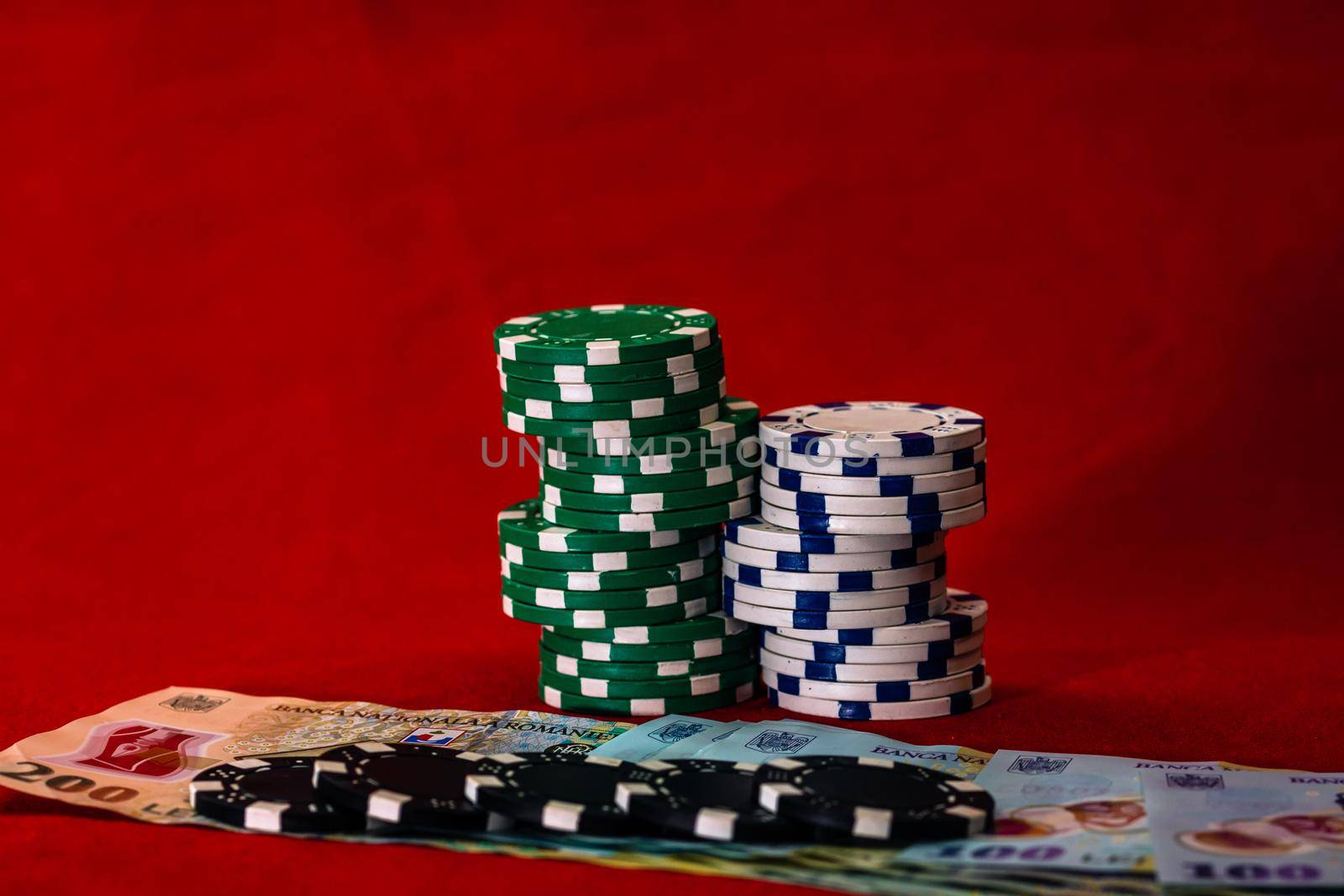 Stacks of poker chips with money on red background, Romanian LEI currency