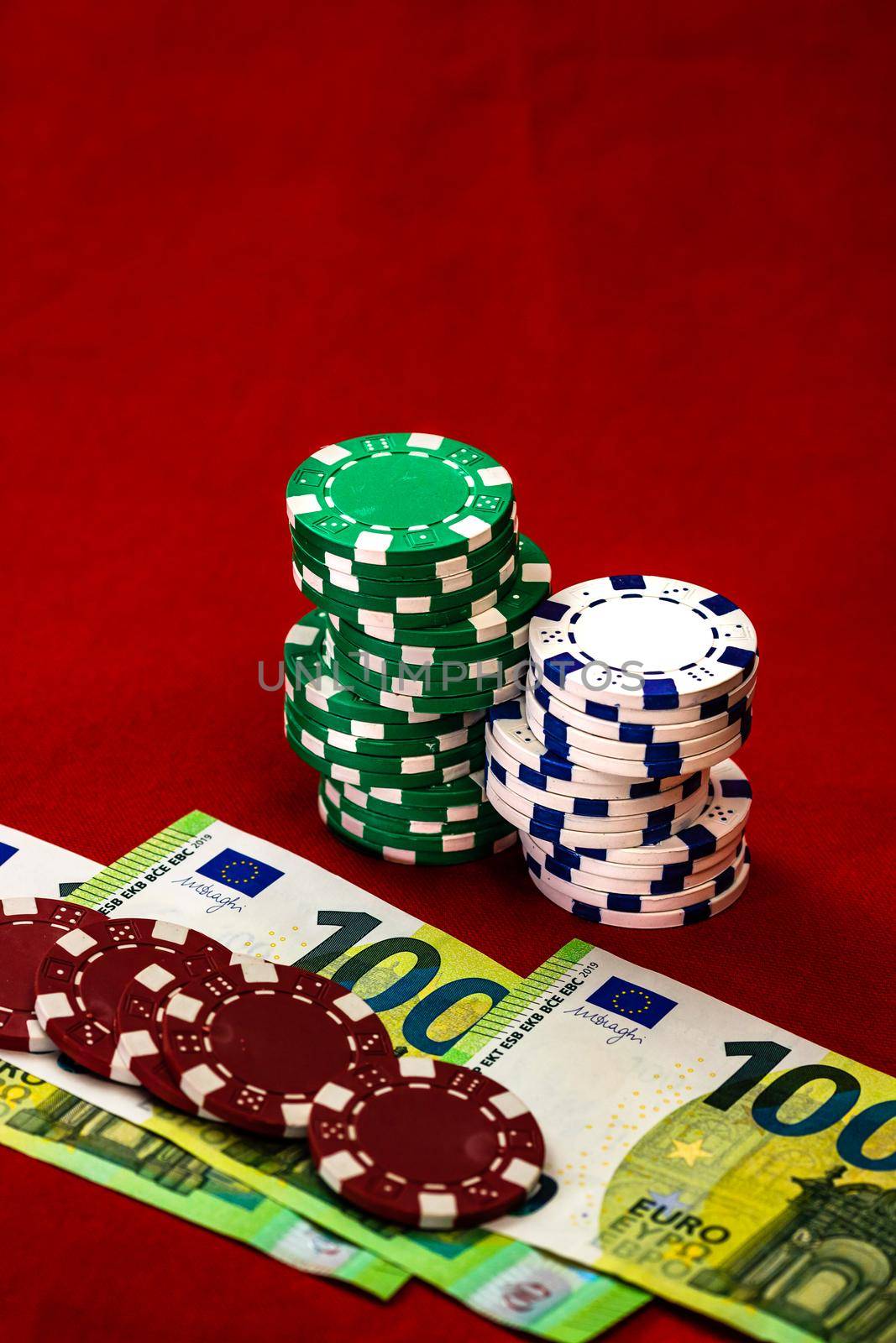 Stacks of poker chips with money on red background, EURO currency