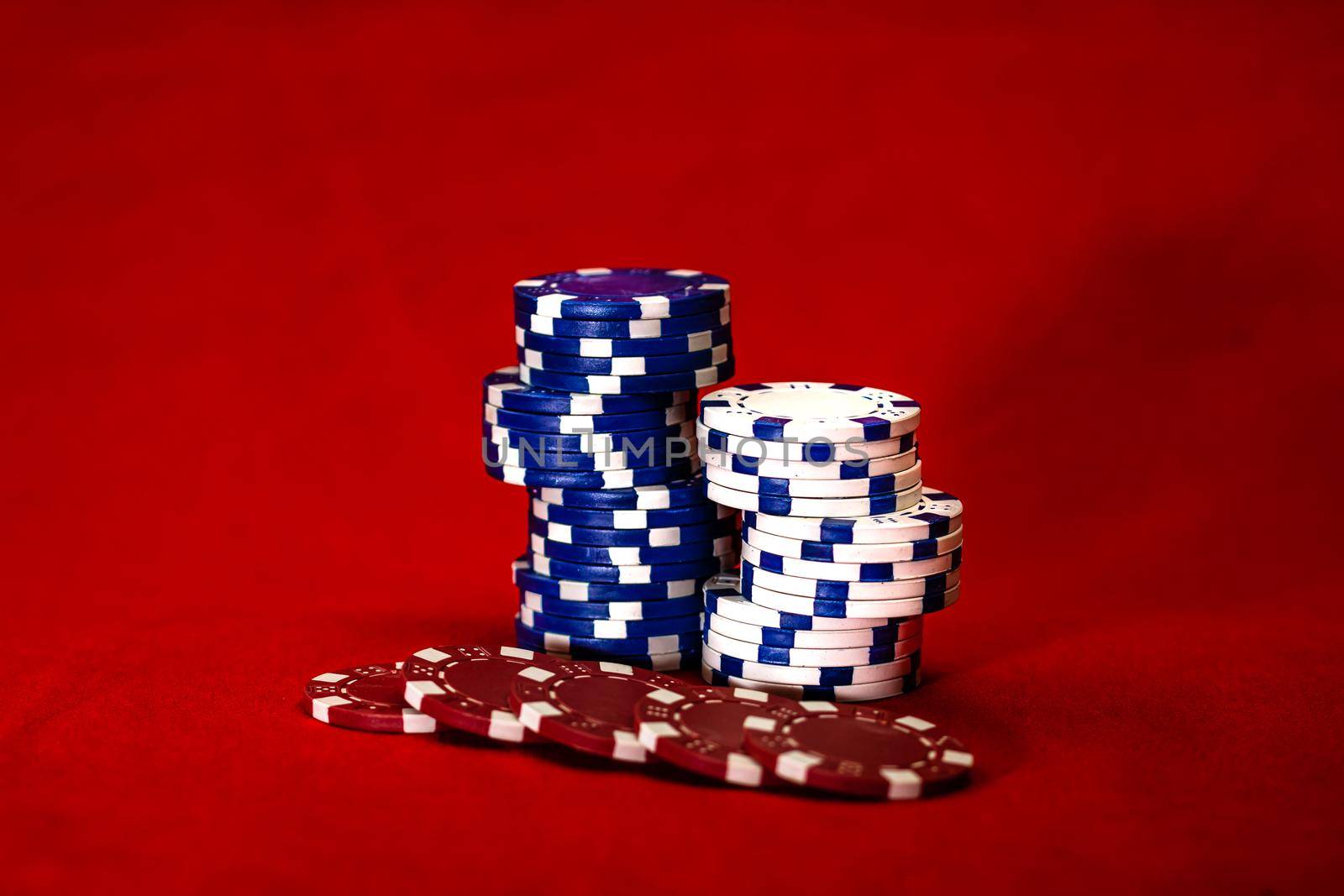 Mix of poker chips on red background