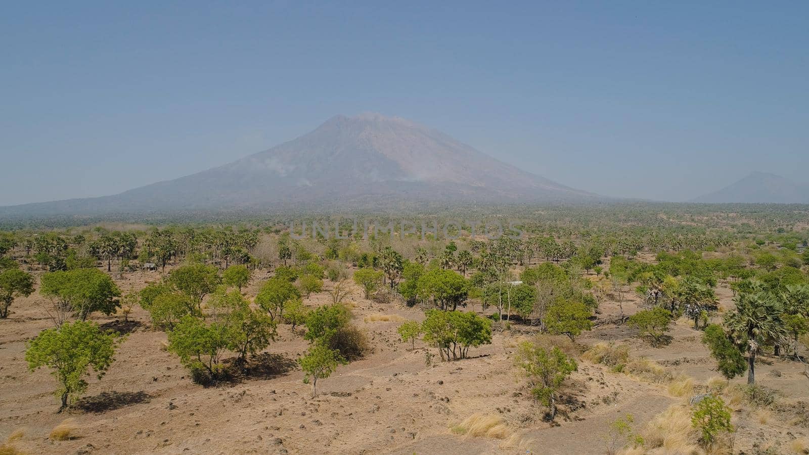 Aerial view volcano mount Agung Bali, Indonesia. tropical landscape savanna with low trees at foot volcano. Rural mountain landscape.