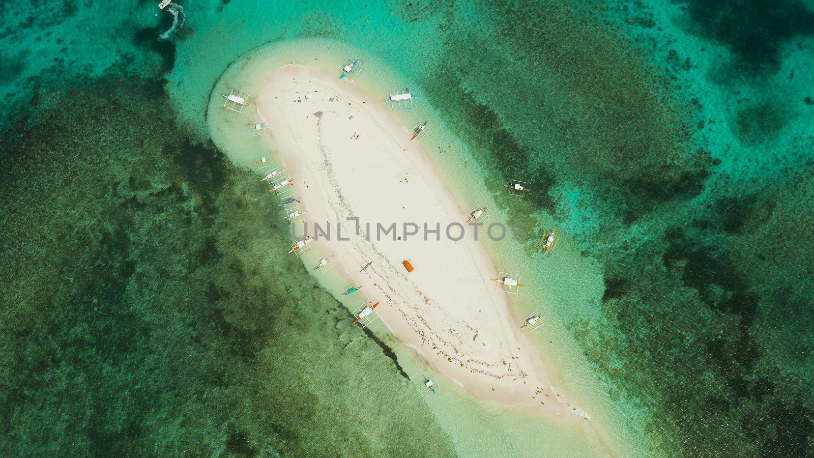 Beautiful beach on tropical island surrounded by coral reef, sandy bar with tourists, top view. Sandbar Atoll. Summer and travel vacation concept, Naked Island, Siargao.