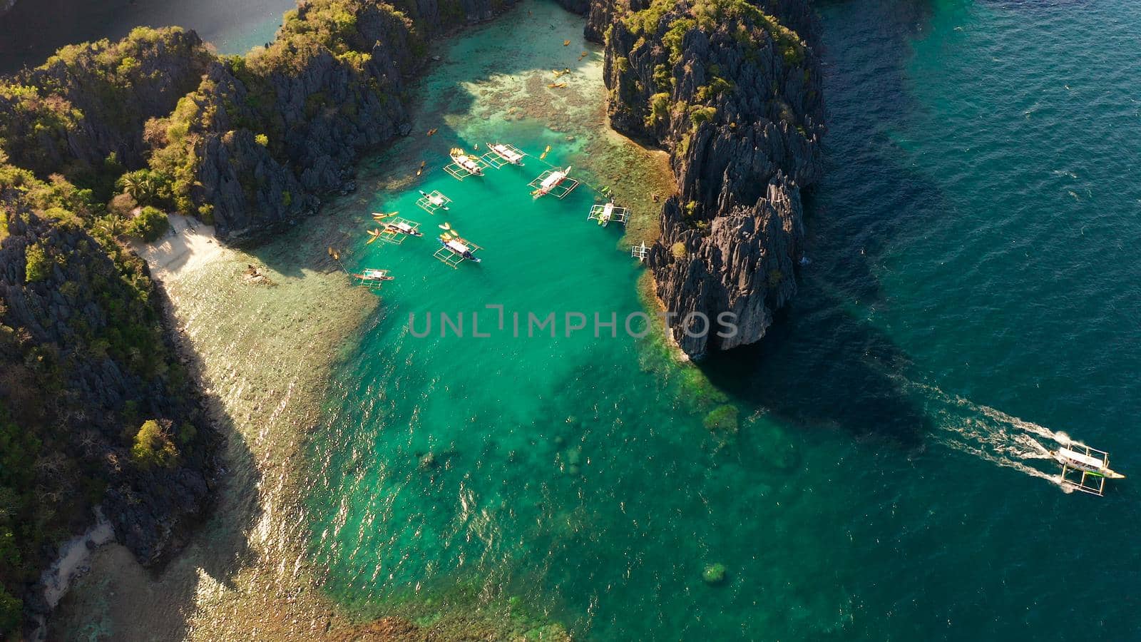 Tourist boats over tropical lagoon and coral reef, aerial view. Small lagoon with turquoise water. El nido, Philippines, Palawan. Summer and travel vacation concept.