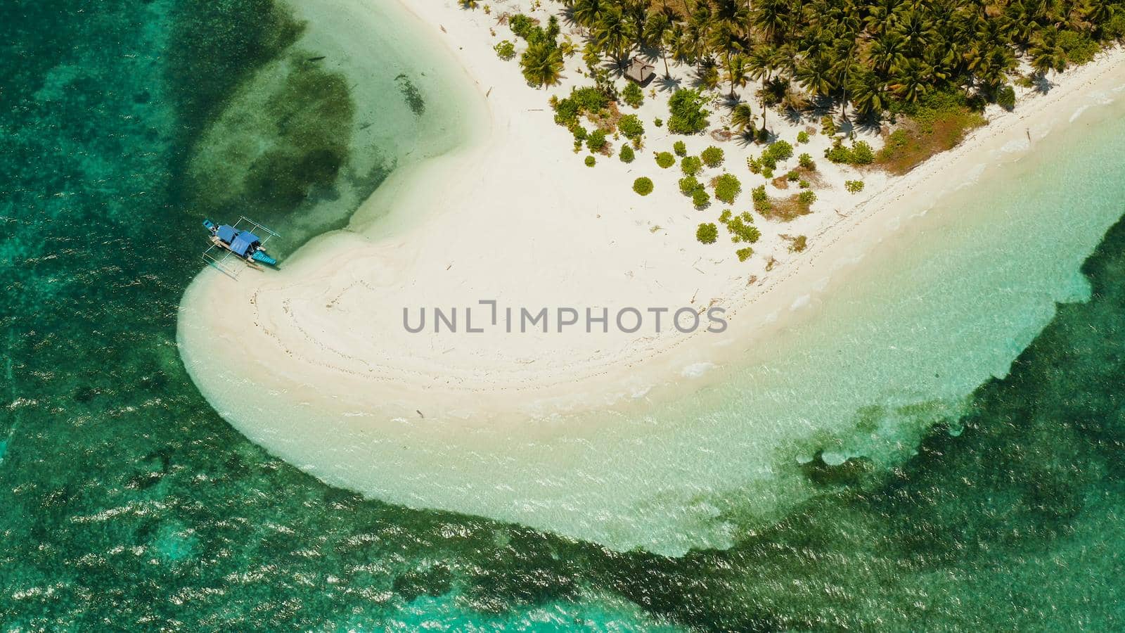 Sandy beach and tropical island by atoll with coral reef, top view. Patongong Island with sandy beach. Summer and travel vacation concept.