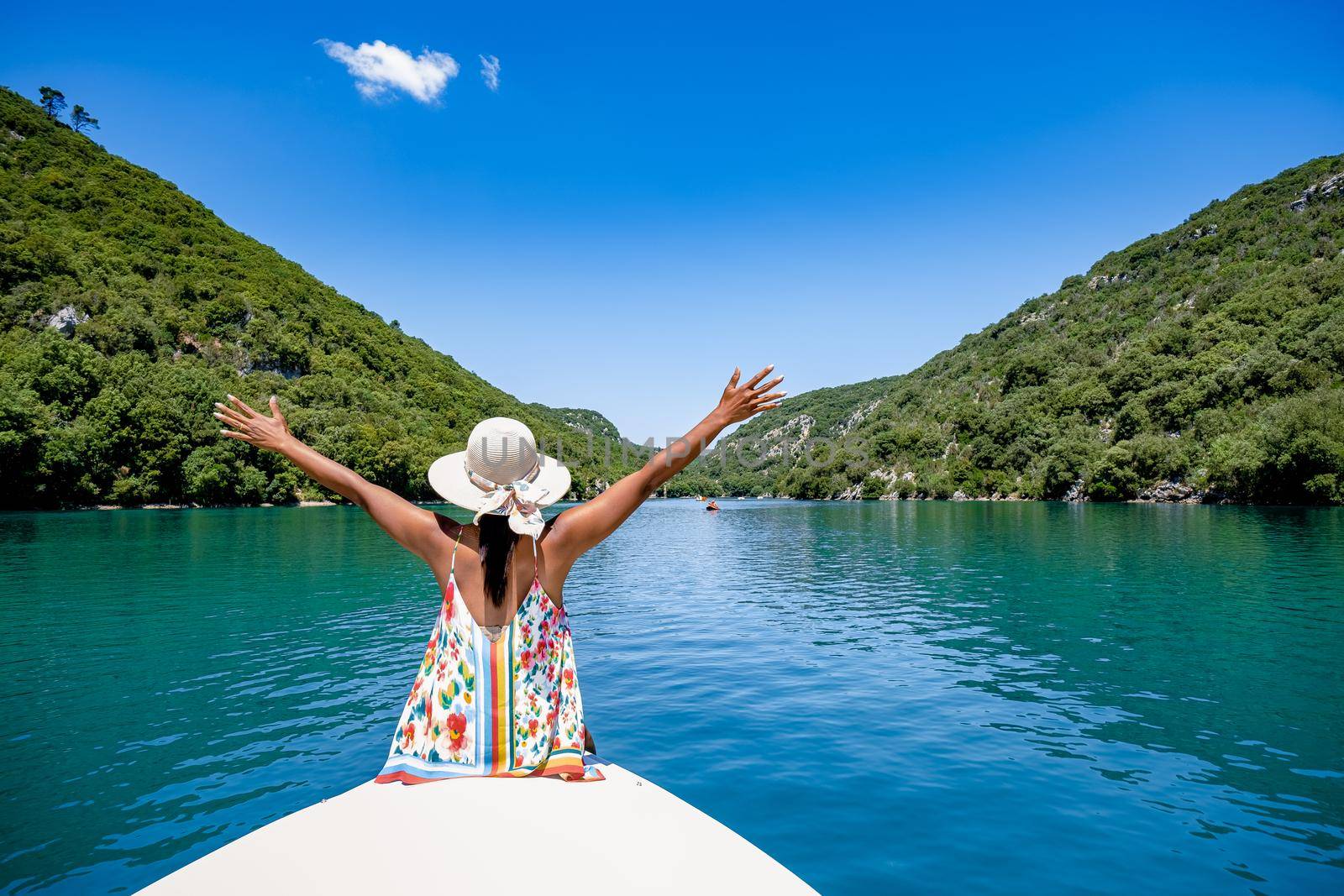 cliffy rocks of Verdon Gorge at lake of Sainte Croix, Provence, France, Provence Alpes Cote d Azur, blue green lake with boats in France Provence. Europe, young woman in peddle boat looking at river