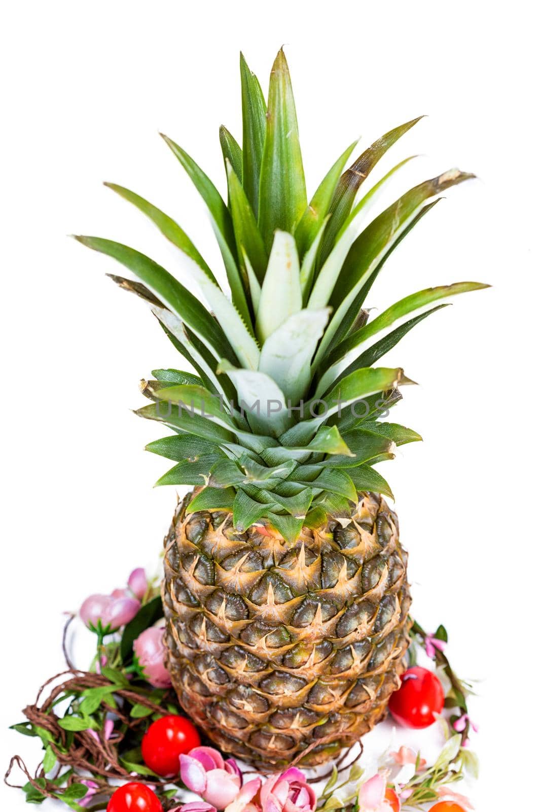 Easter composition of pineapple, flower wreath and colored eggs isolated on white background