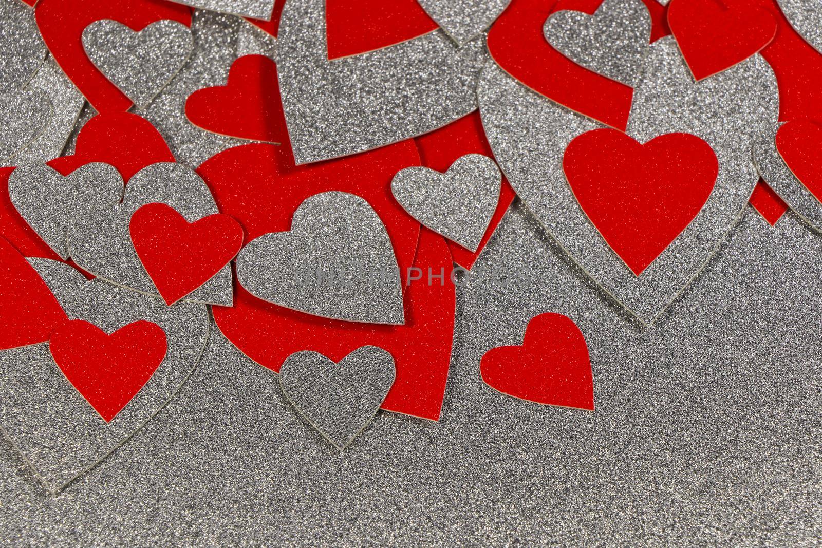 Saint Valentine's day scattered red and silver hearts on silver background