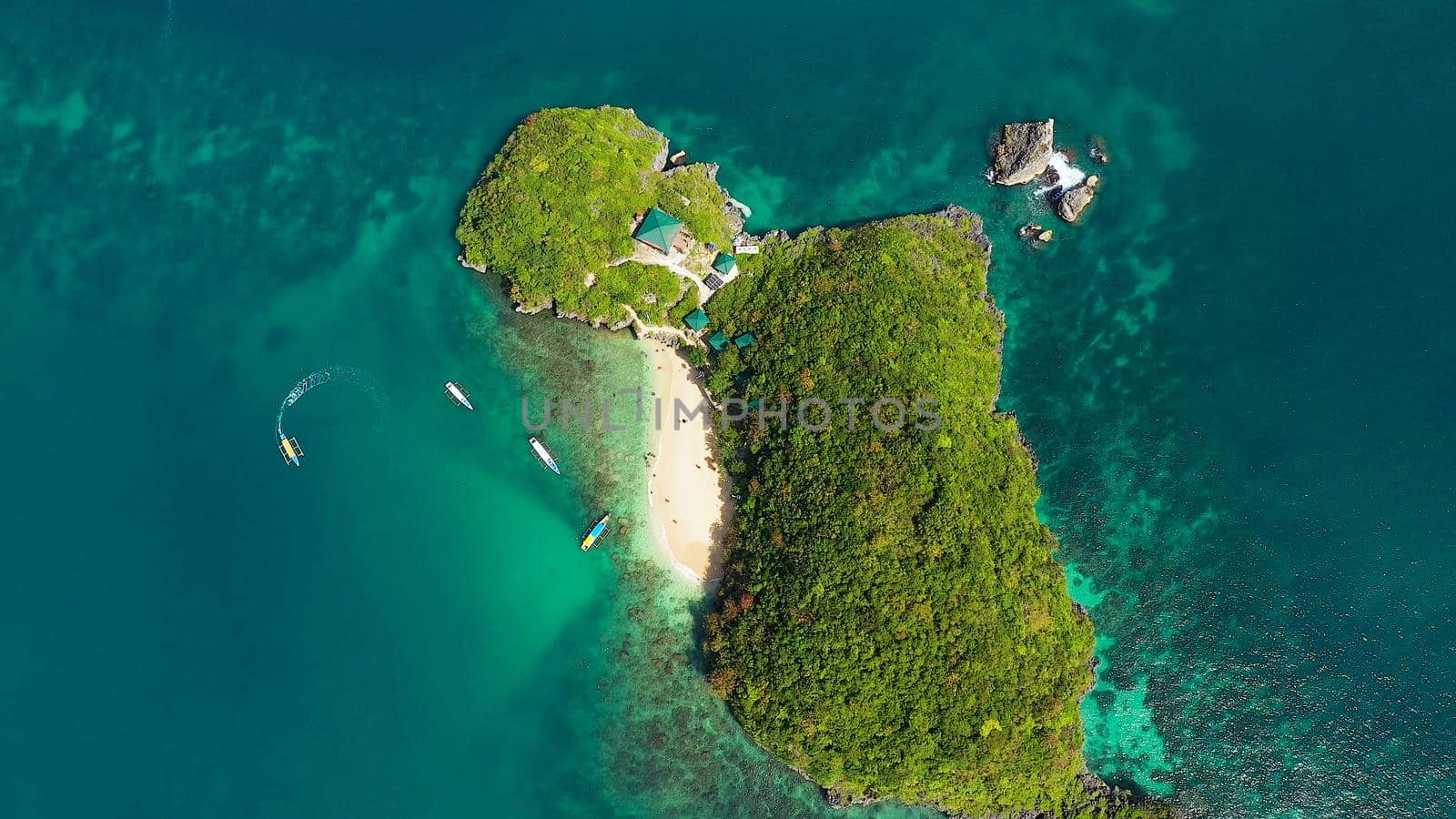 Travel concept: Sandy beach and turquoise water. Tourists on a tropical beach, aerial view. Marcos Island, Hundred Islands National Park, Pangasinan, Philippines. Alaminos. Summer and travel vacation concept