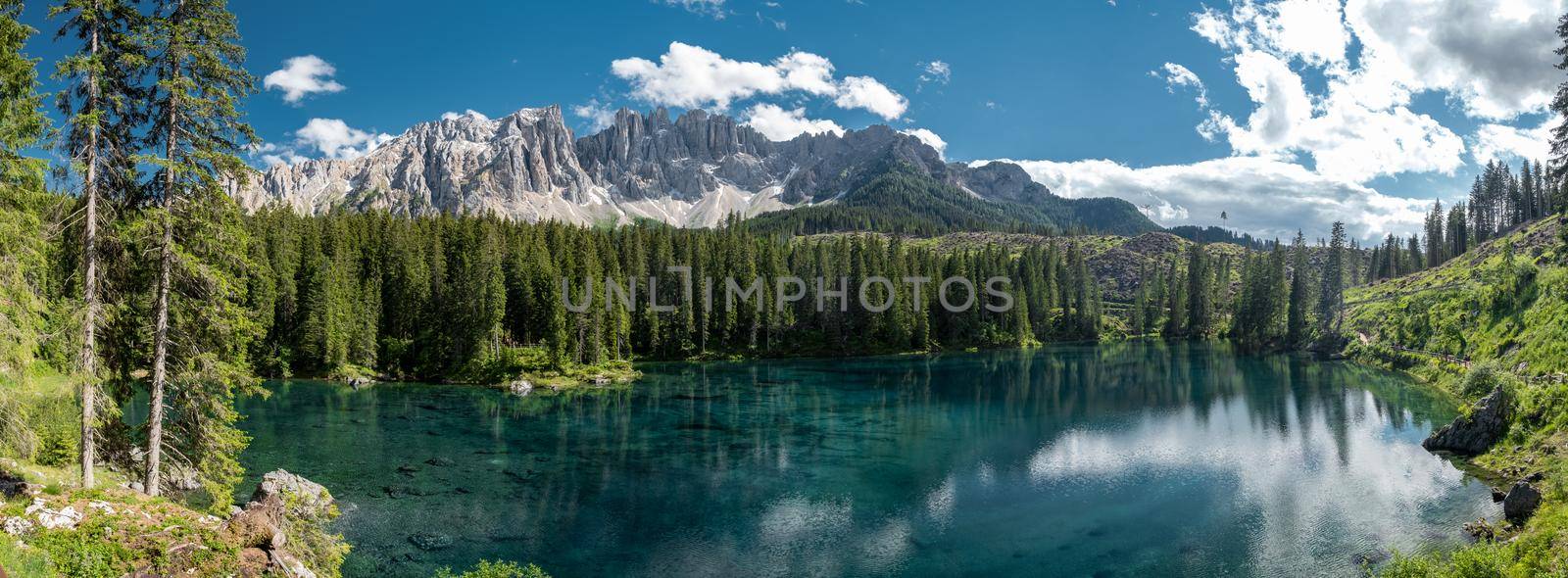 The majestic Lake of Lago di Carezza, beautiful green and turquoise colors in Dolomites mountains Italy,South tyrol, Italy. Landscape of Lake Carezza or Karersee  by fokkebok