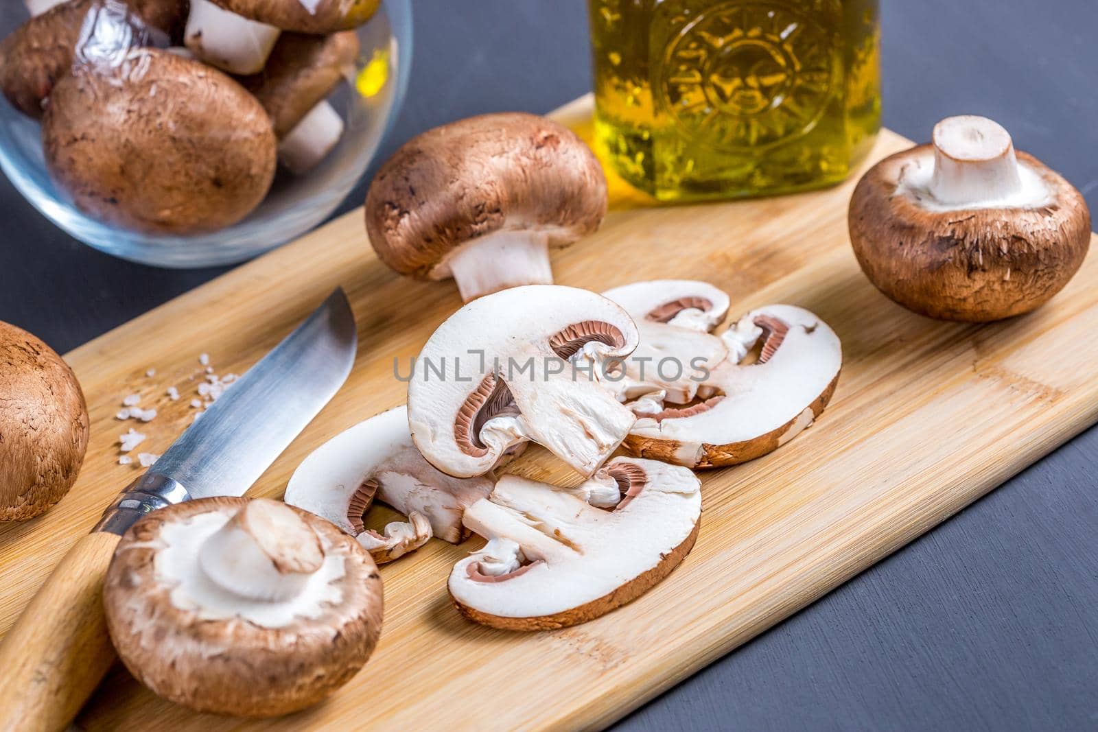 Close-up of a slice of edible mushroom champignons on a cutting board. by galinasharapova