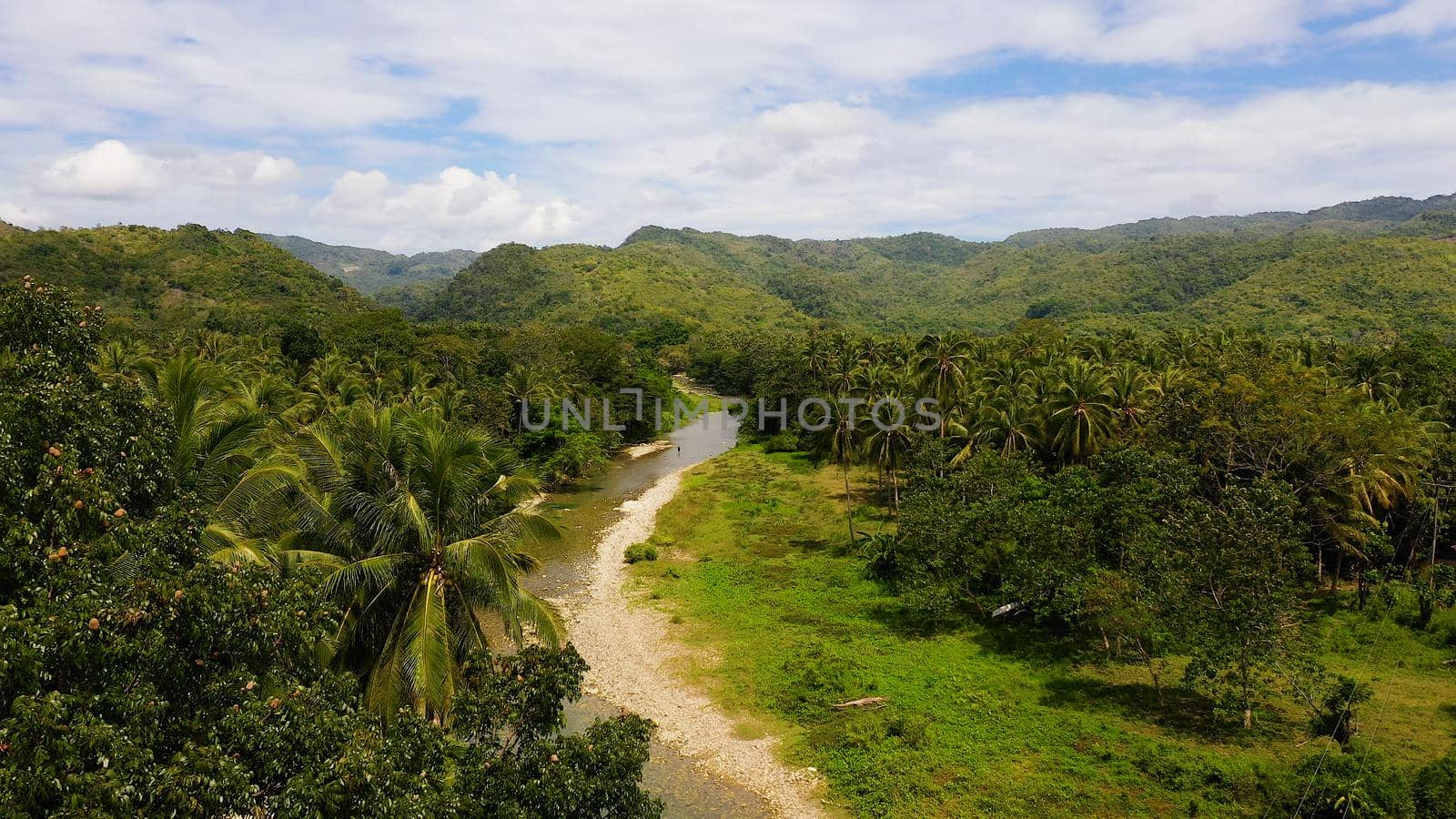 Mountains and hills are covered with evergreen forest. Beautiful landscape in the Philippines. A river in the mountains on Leyte Island, Philippines.