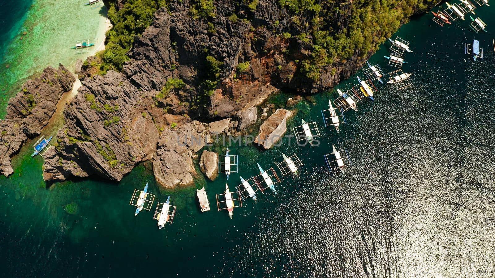 Tourist boats over tropical lagoon and coral reef. El nido, Philippines, Palawan. tropical landscape bay with beach and clear blue water surrounded by cliffs