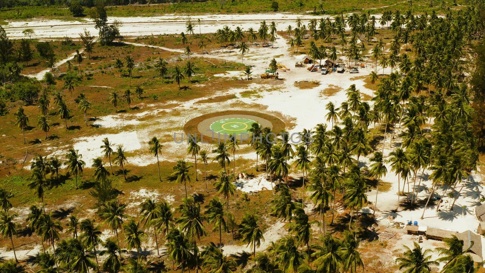 Helipad among the palm trees on a tropical island top view. Helicopter landing site. Bugsuk island, Balabac, Palawan