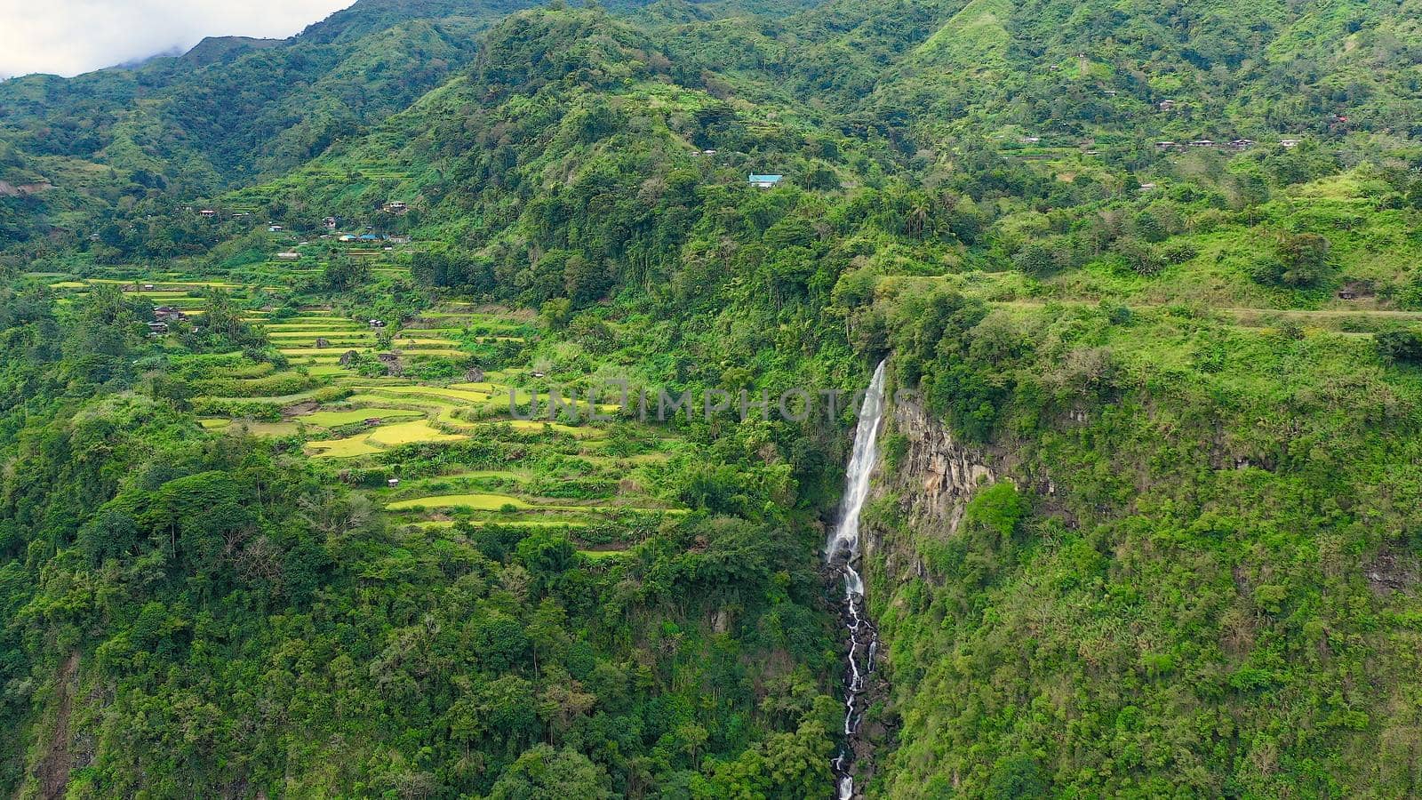 Mountain landscape with rainforest and waterfall, aerial view. Highlands with villages on the island of Luzon, Philippines.