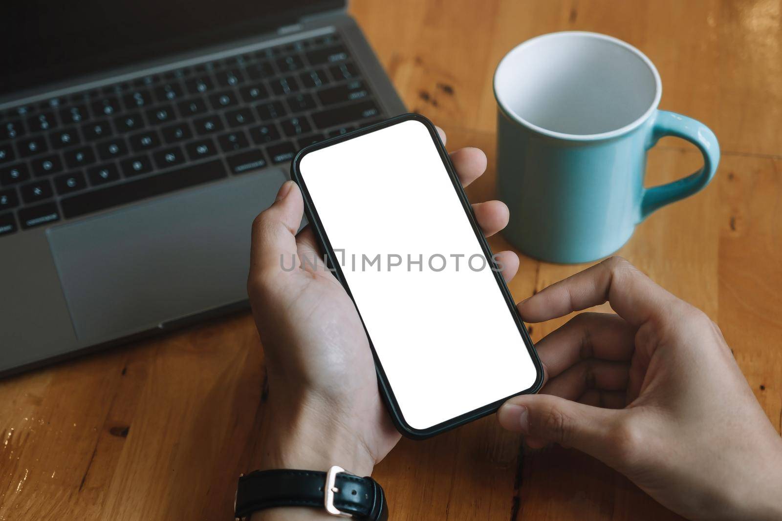 Mockup image blank white screen cell phone.men hand holding texting using mobile relax on sofa at home. background empty space for advertise text.people contact marketing business and technology