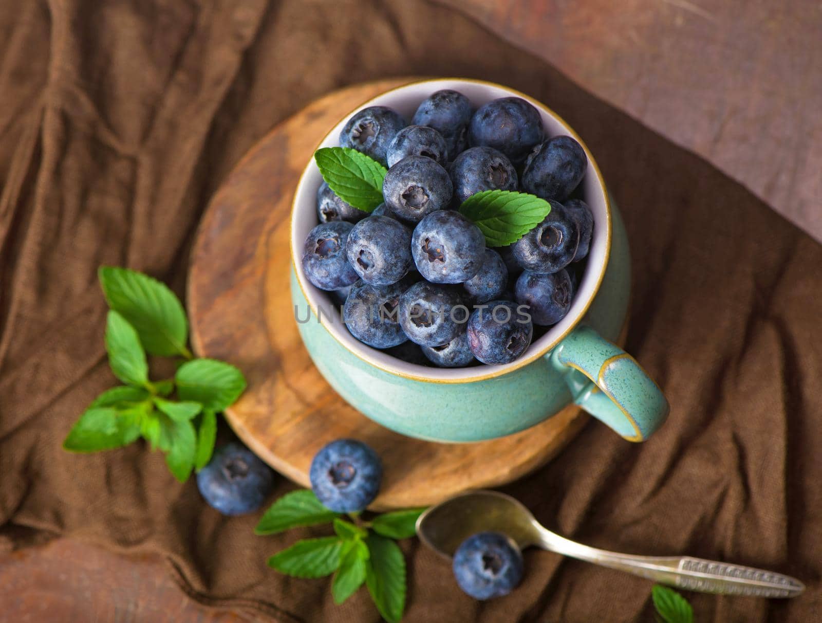 Fresh blueberry in a cup with leaves of mint by aprilphoto