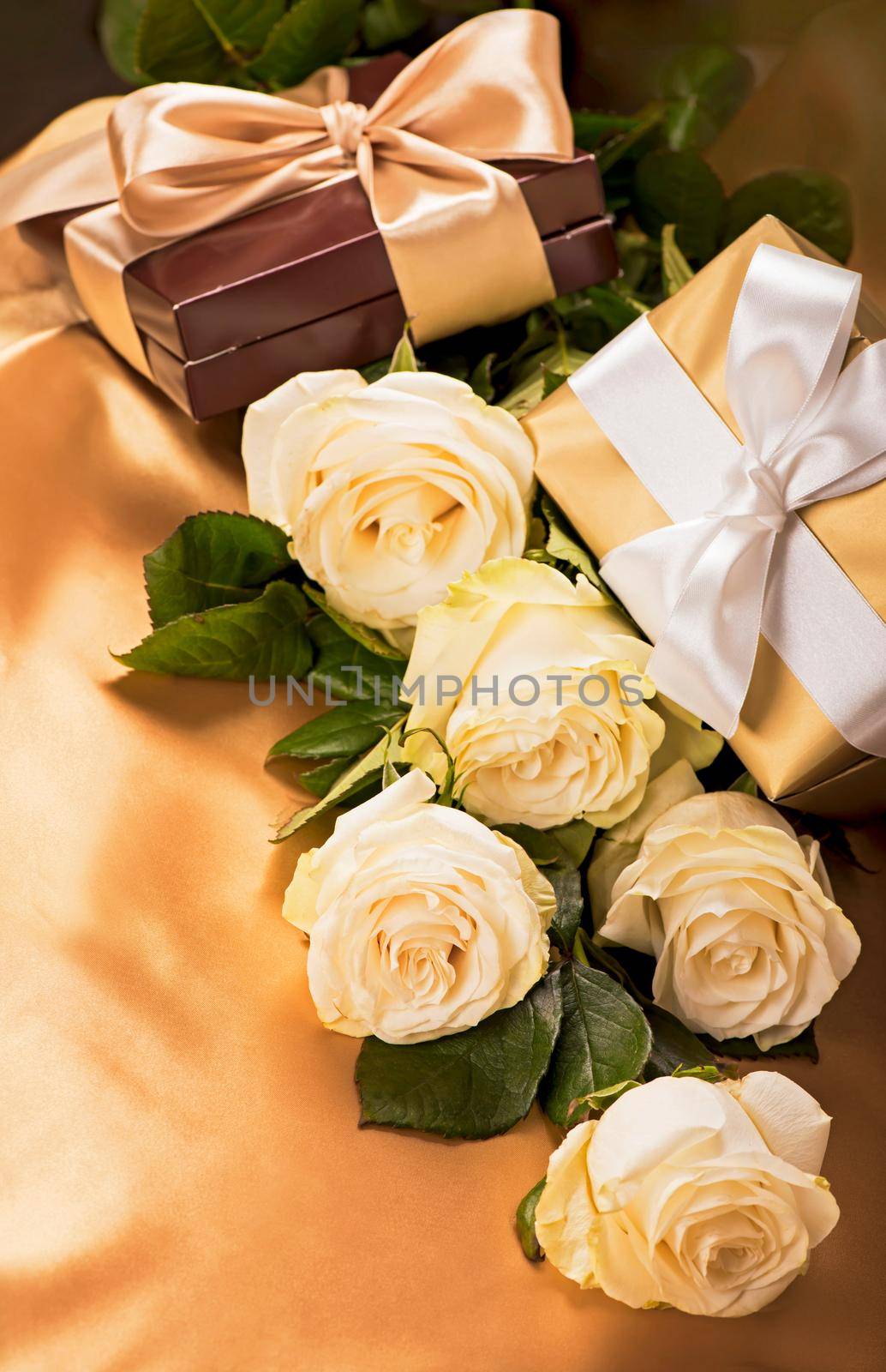 flowers and gift. white roses on golden silk background by aprilphoto