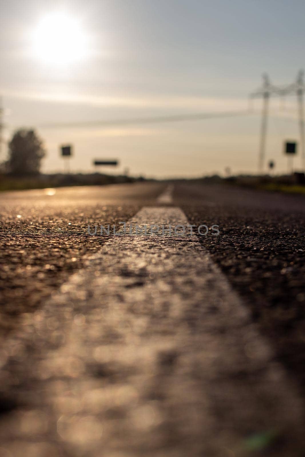 A long white stripe, like a road marker. A road into the distance between fields and forests. High quality photo