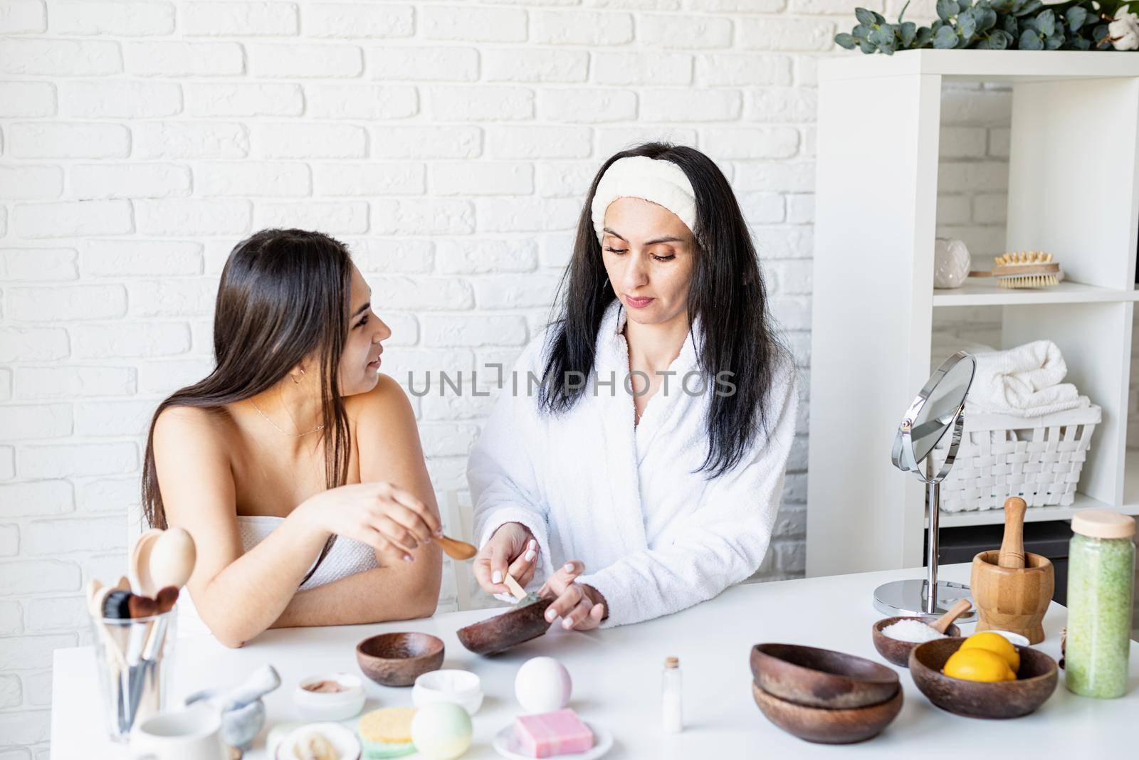 Spa and wellness concept. Self care. two beautiful women making facial mask doing spa procedures