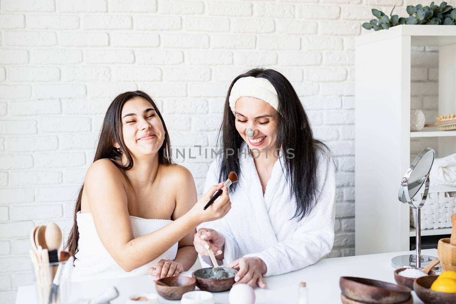 Spa and wellness concept. Self care. two beautiful women making facial mask having fun