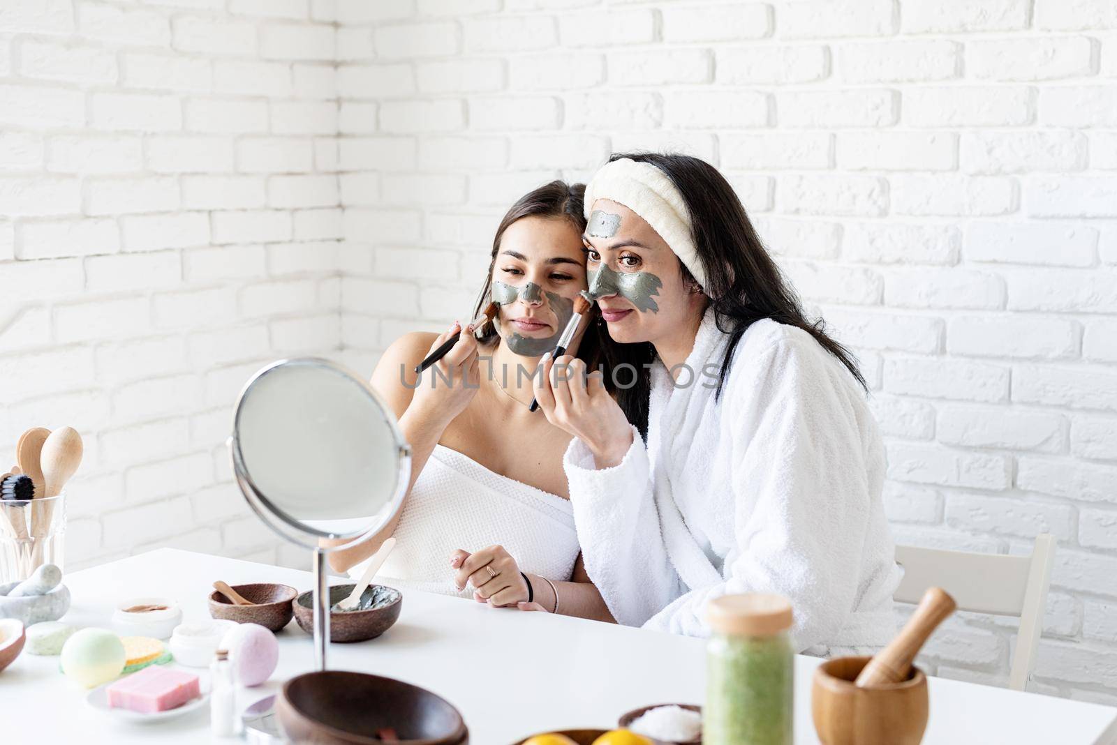 Spa and wellness concept. Self care. two beautiful women applying facial mask having fun