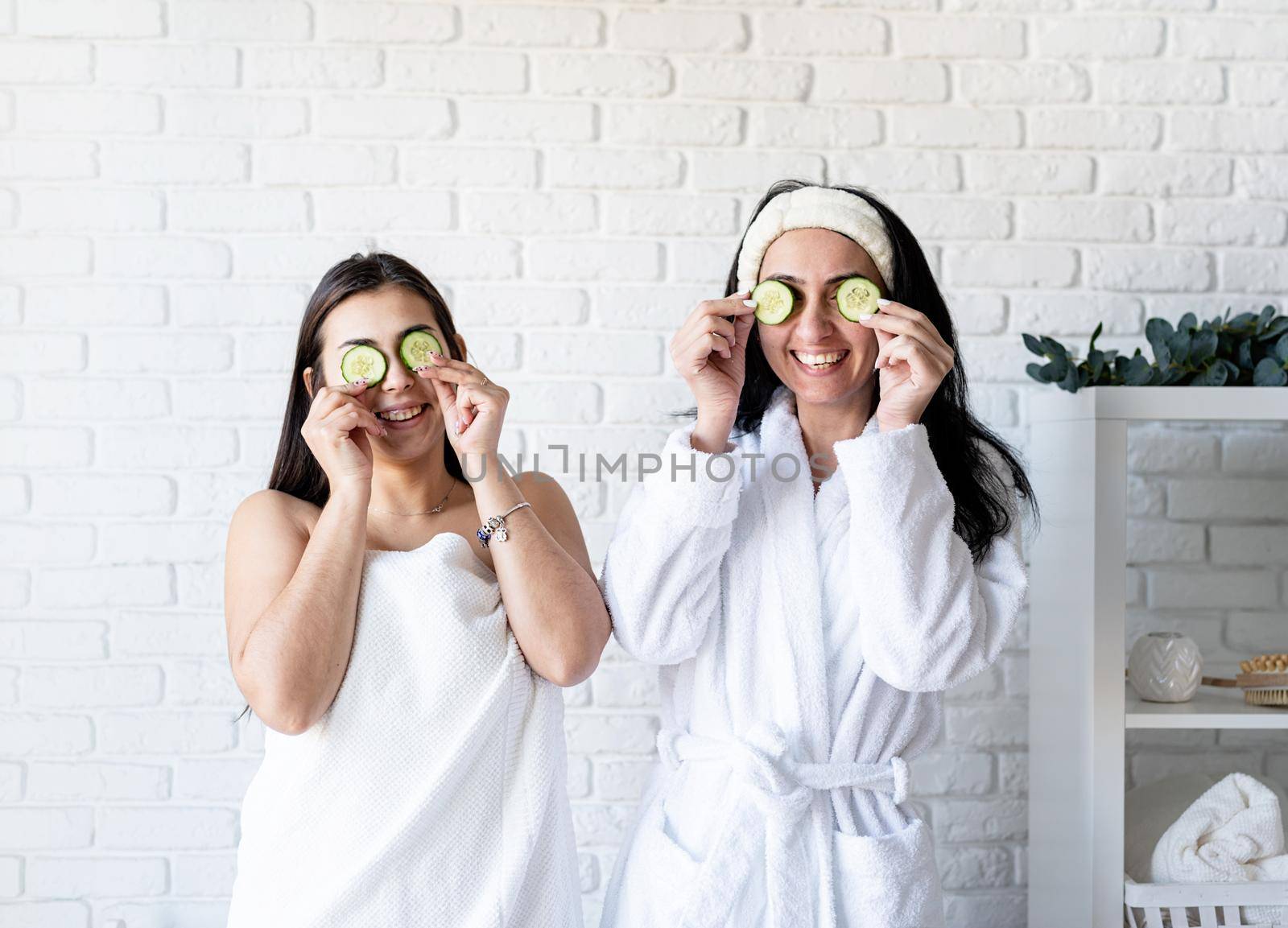 Spa and wellness concept. Self care. two beautiful women doing spa procedures covering eyes with cucumbers