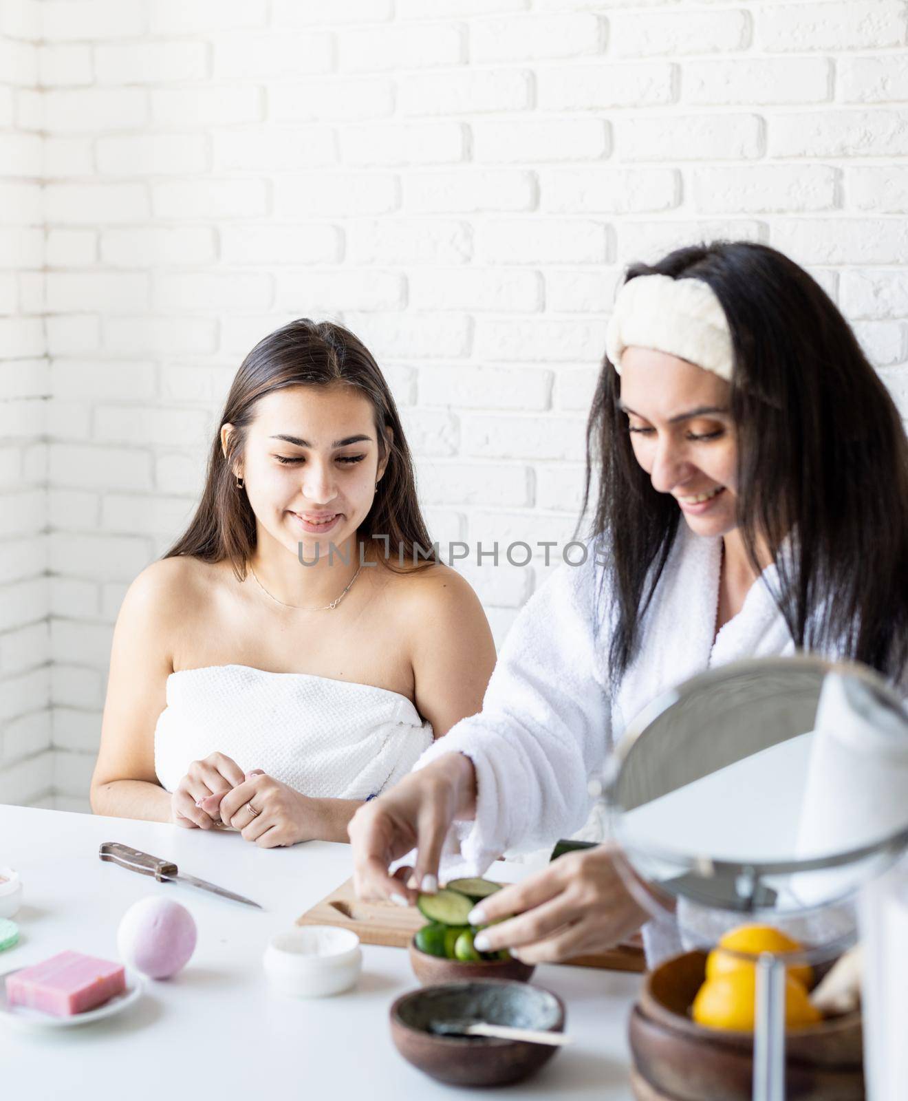 Spa and wellness concept. Self care. two beautiful women doing spa procedures cutting cucumbers