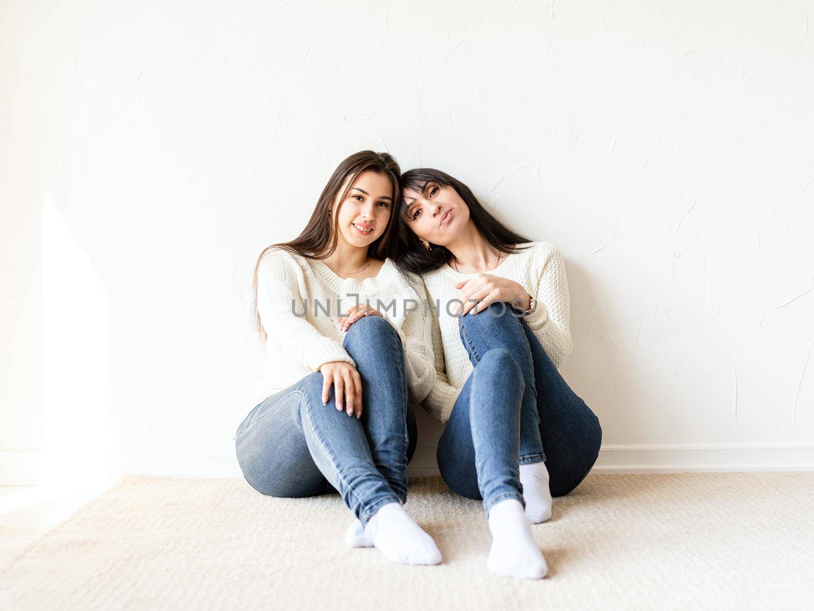 Two female best friends in casual clothes sitting together at home. Copy space