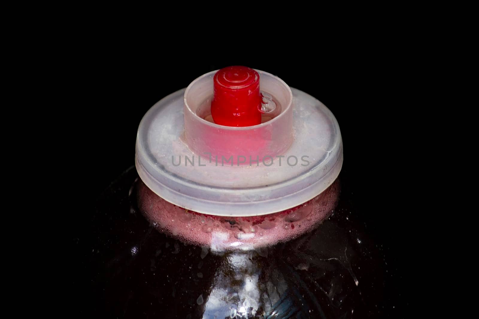 Dressed on top of a jar of fermented wine on a chen background. Front and top view.