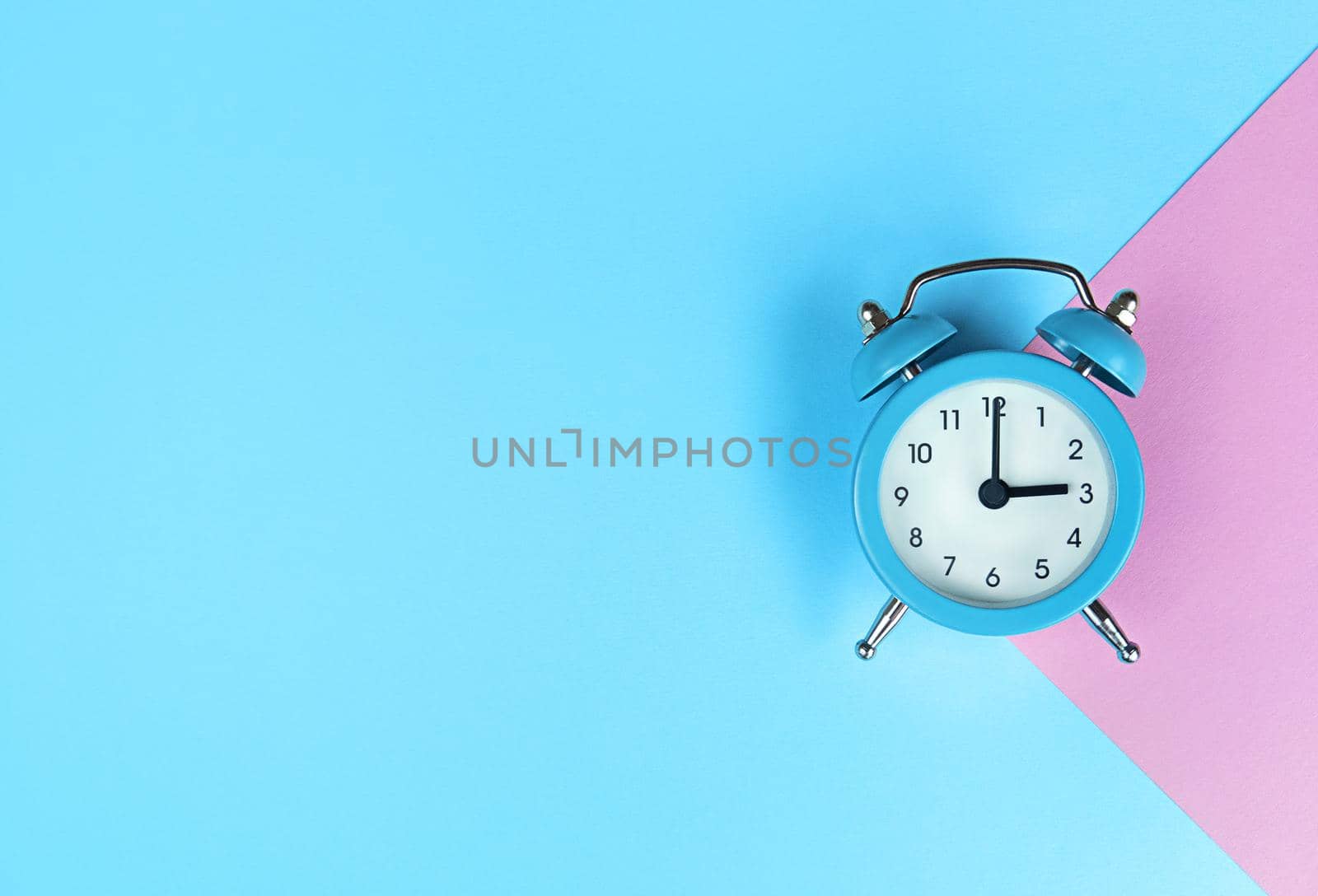 Retro alarm clock on a blue background with copy space.