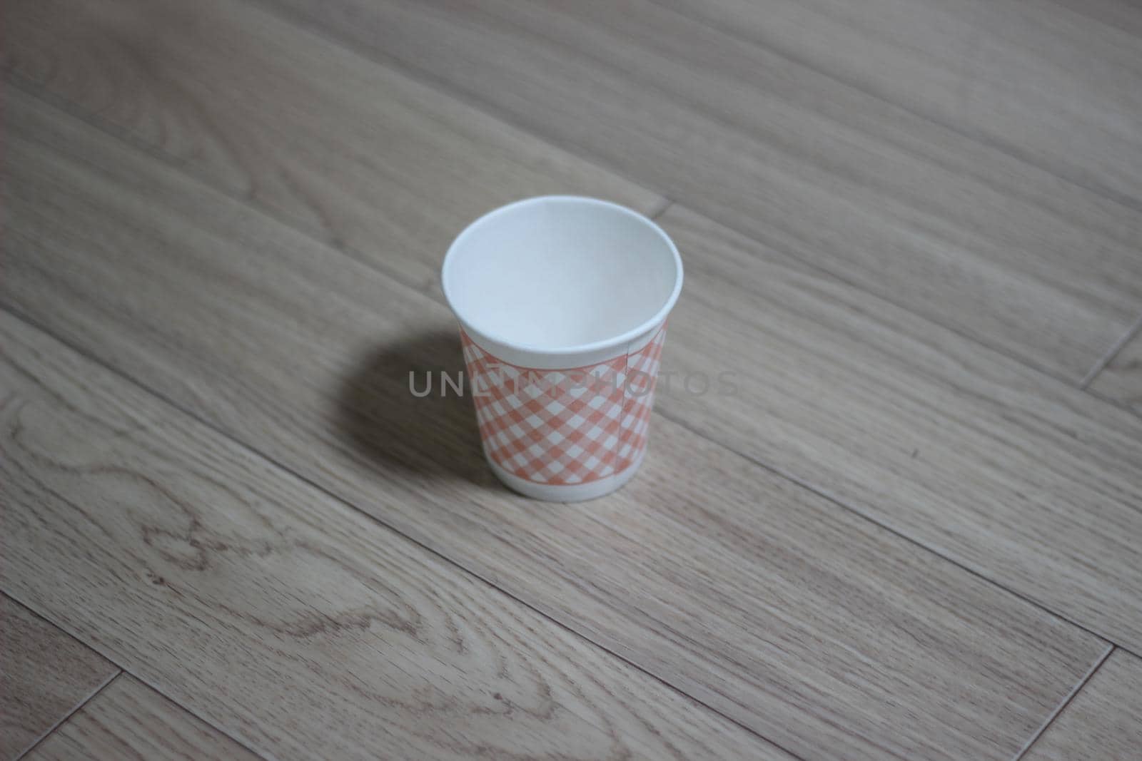 Paper, cardboard disposable glass on a wooden floor. Disposable paper cups on the wooden floor