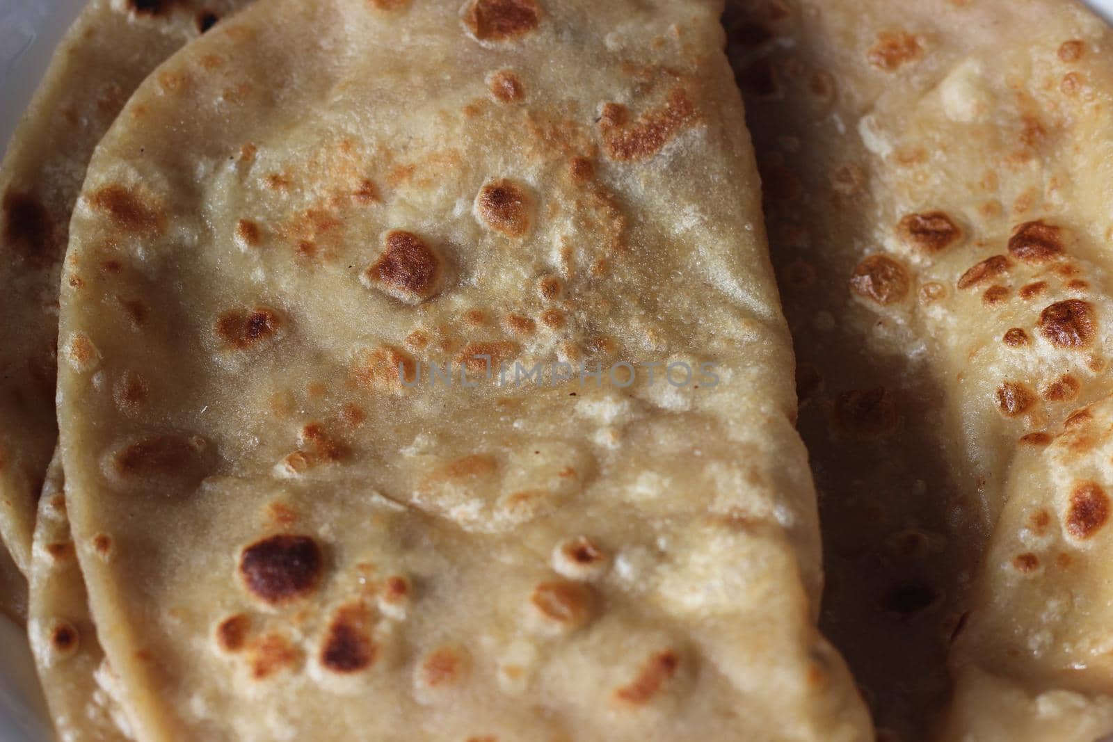 Closeup view of hand made plain bread in oil called paratha roti. Paratha is popular in India, Pakistan and other South Asian countries. Texture for bread.