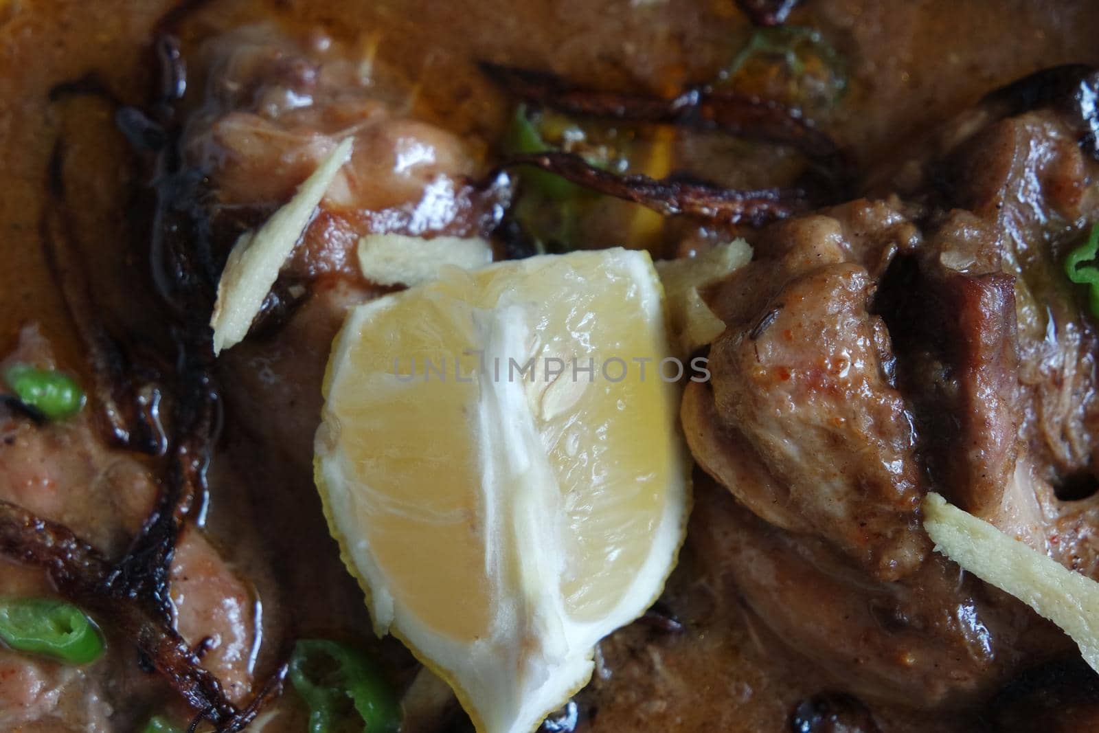 Closeup view of traditional Pakistani Haleem dish with salad and Lemon juice.