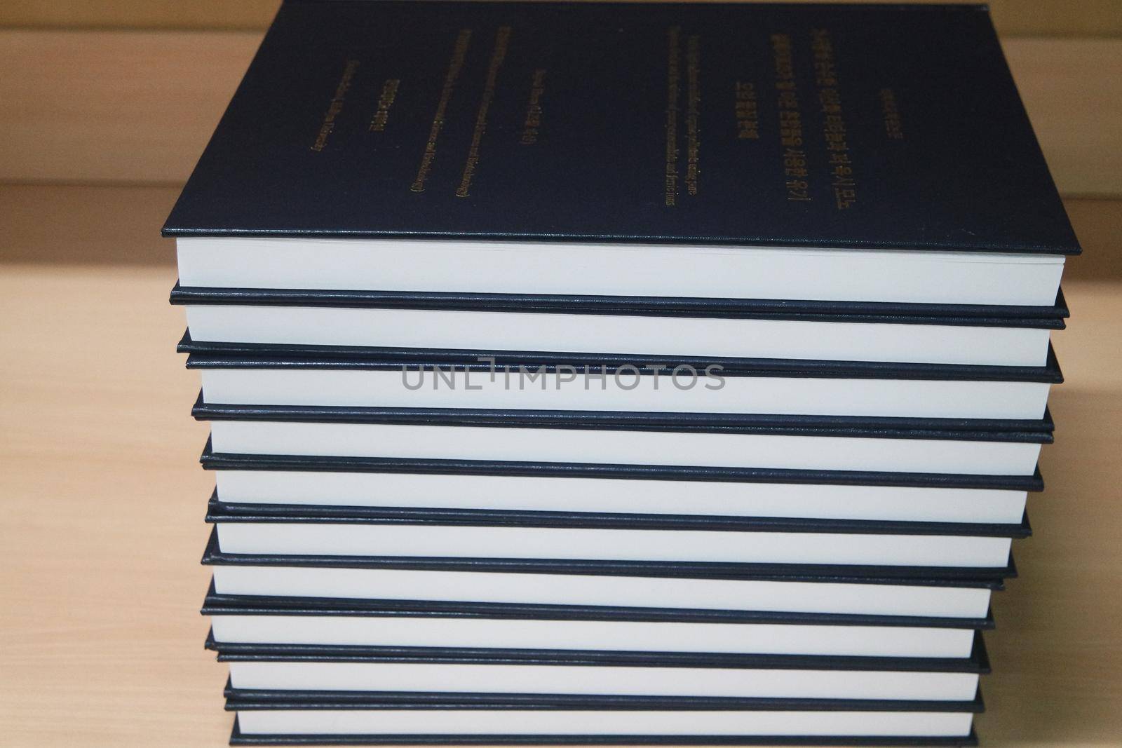 Stack of blue books placed on table. by Photochowk