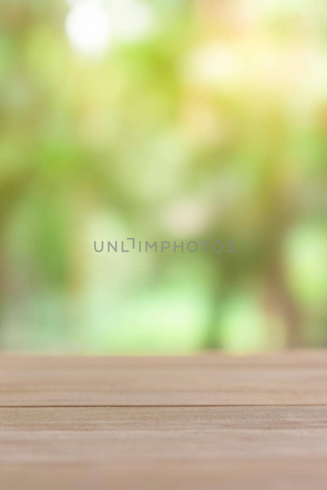 Empty wooden table with green blur light background.