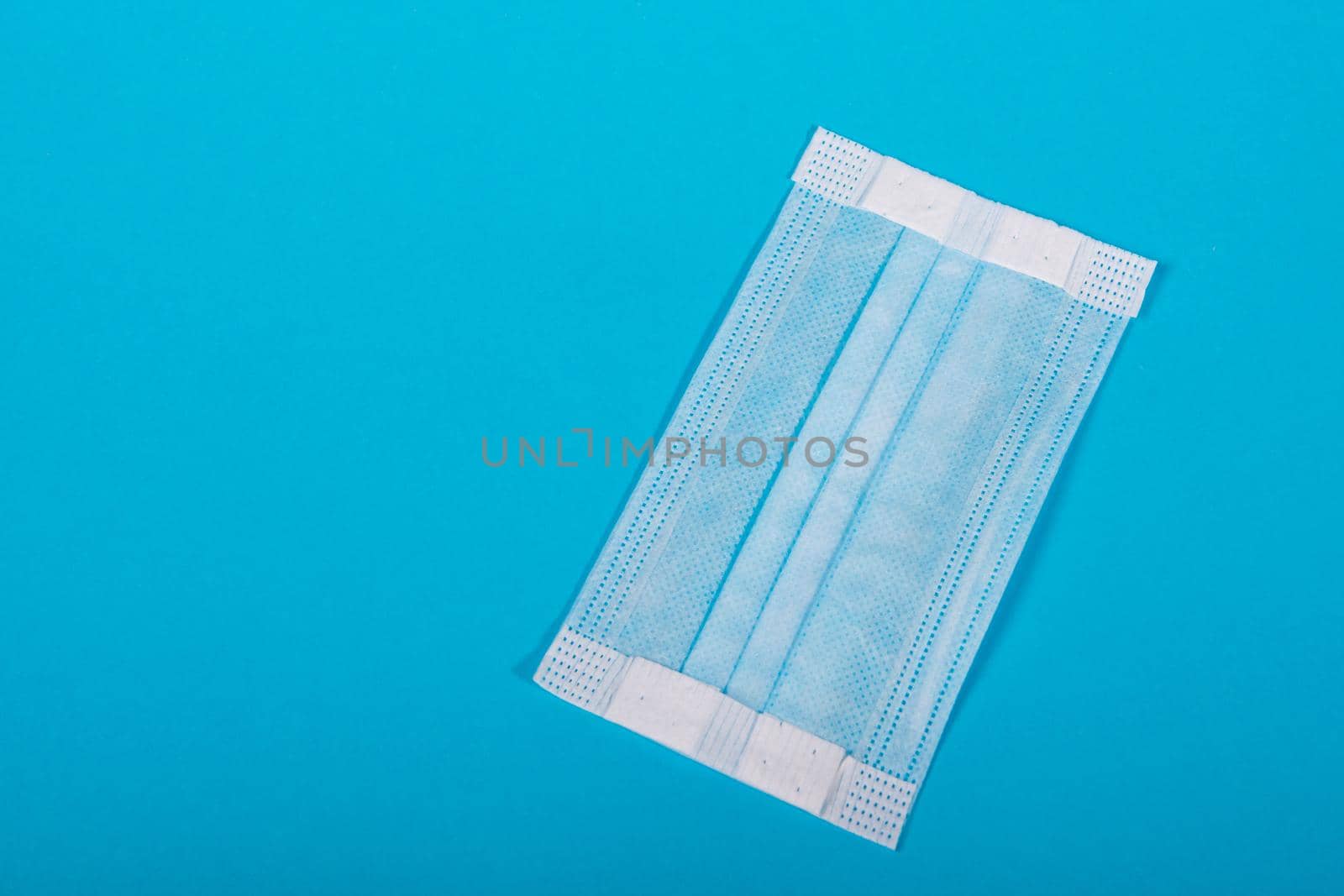 Medical mask on a blue background with copy space.