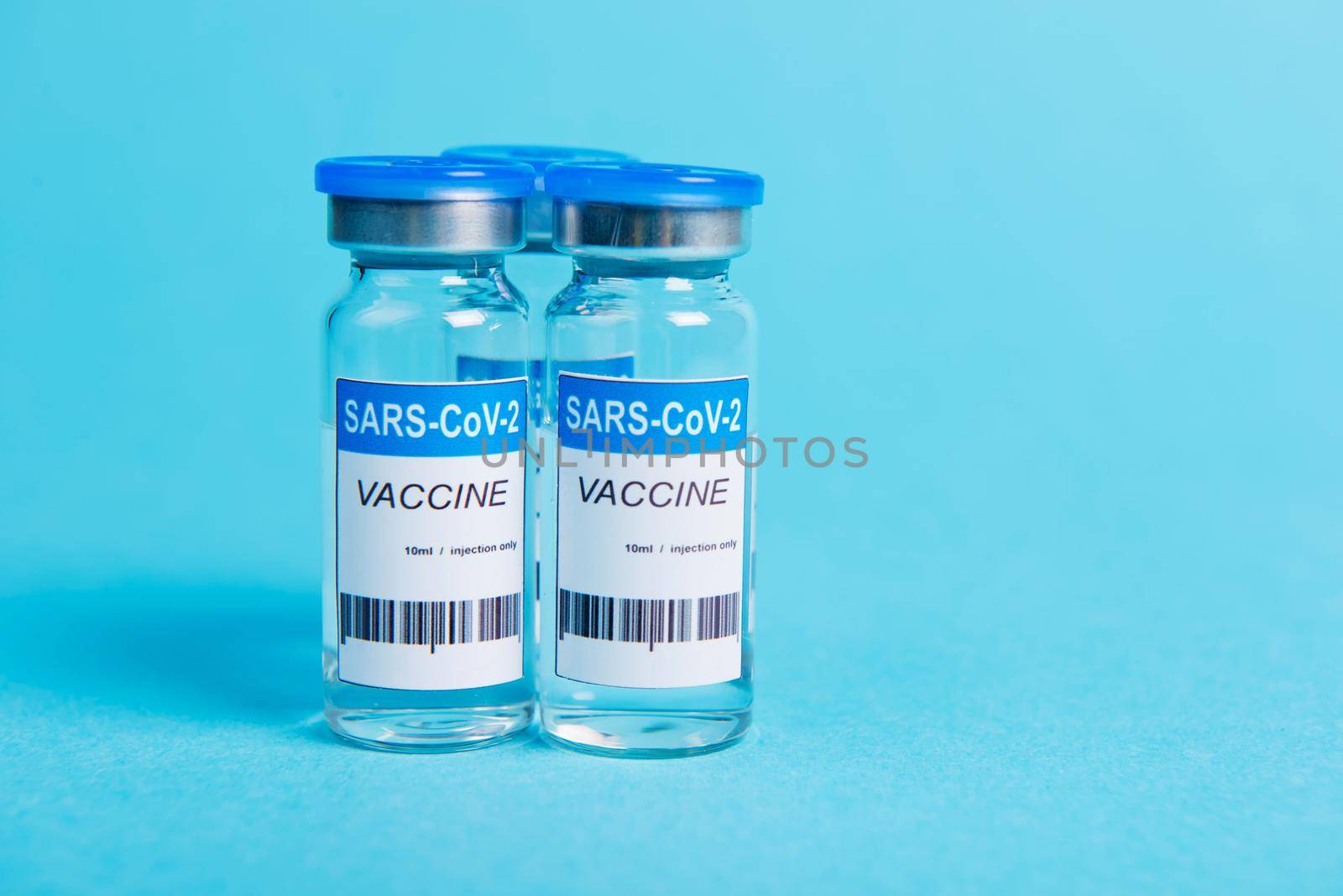 covid-19 coronavirus vaccine bottle on blue background.