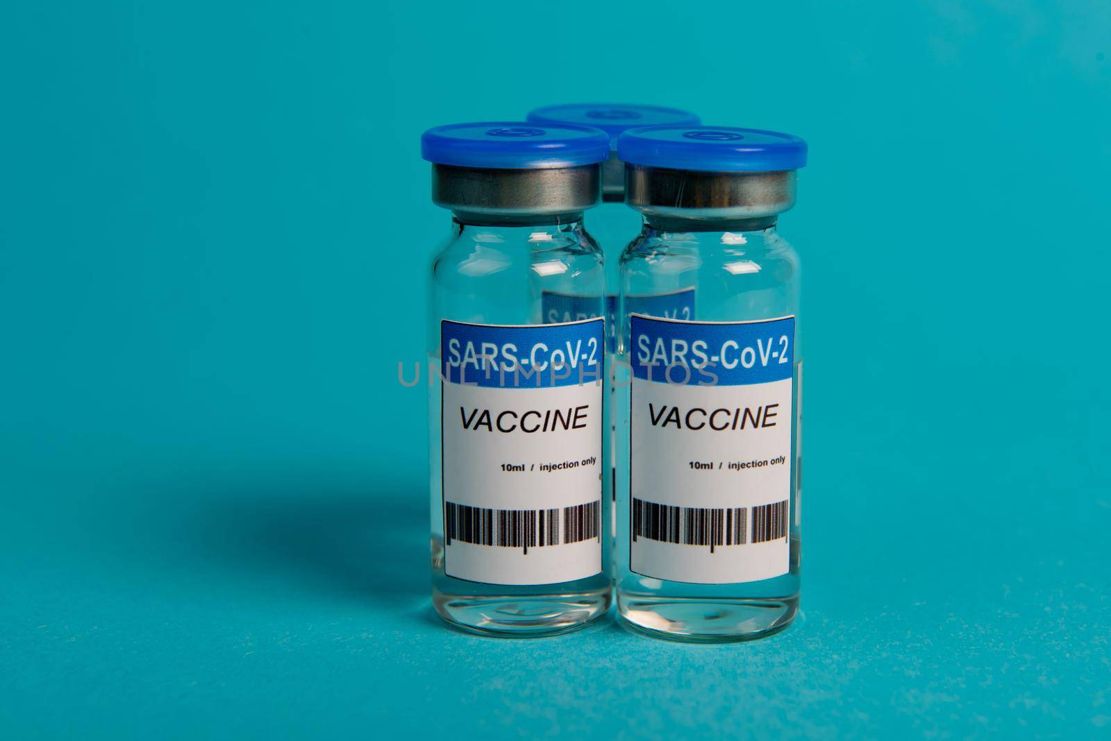 Covid-19 coronavirus vaccine bottle on blue background. Selective focus.