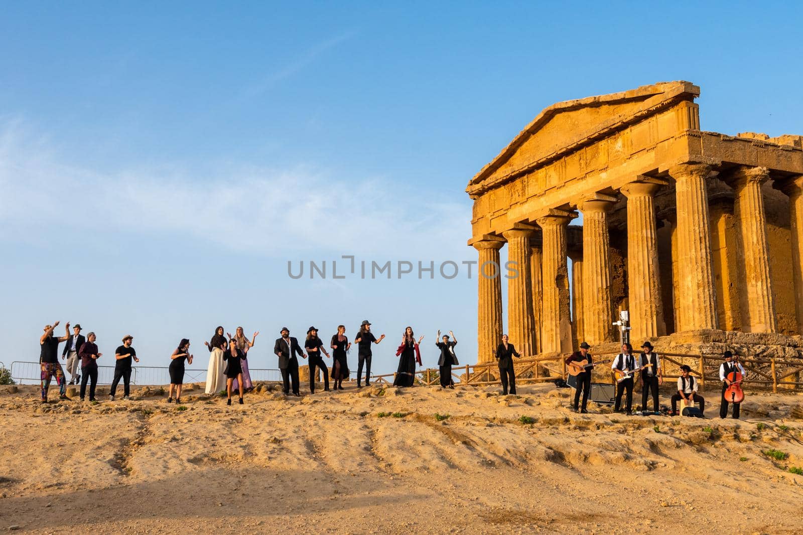 Agrigento, Italy - 14 8 2020: Artists performance at dusk at Concordia Temple by mauricallari