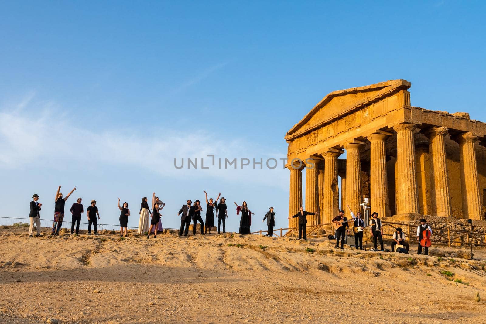 Agrigento, Italy - 14 8 2020: Artists performance at dusk at Concordia Temple by mauricallari