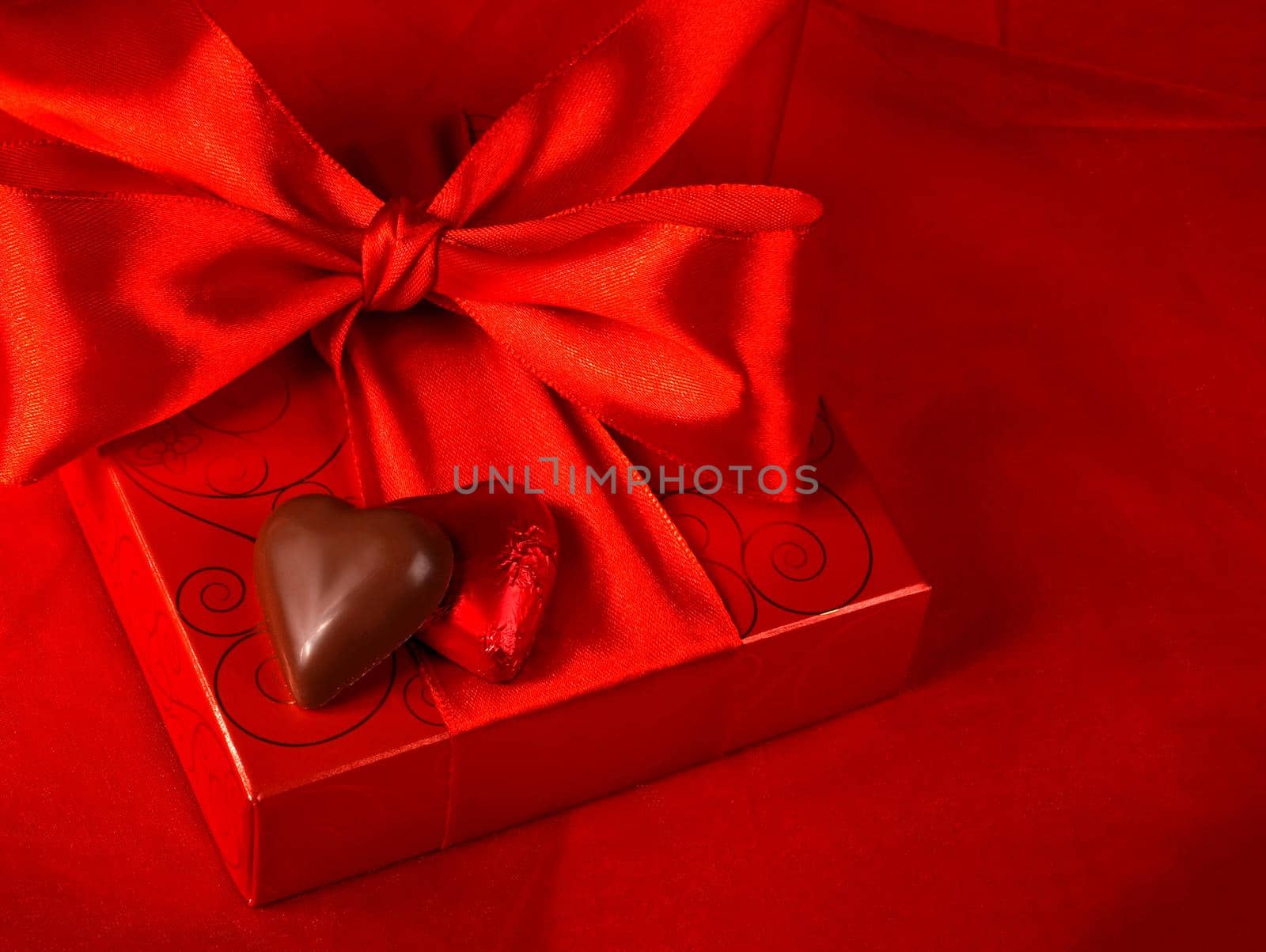 Gift and sweets heart on a red background