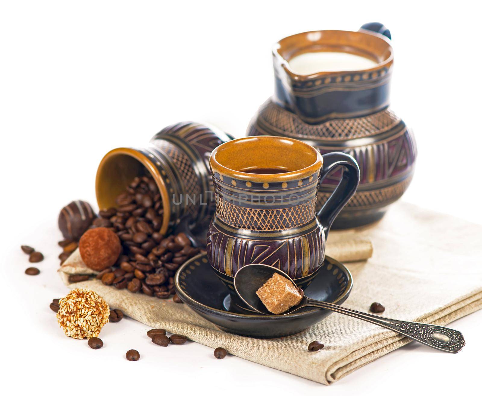 old black pottery, coffee beans, candy and a cup of drink by aprilphoto