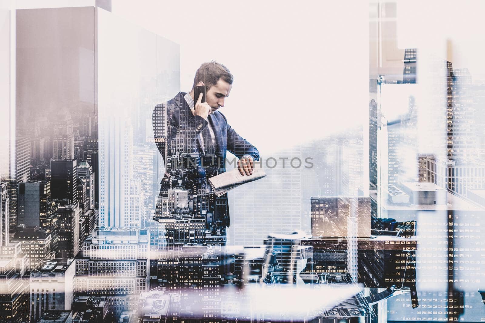 Businessman in modern corporate office, holding financial newspaper, talking on a mobile phone while looking what time is it at his wristwatch. Time is money concept.