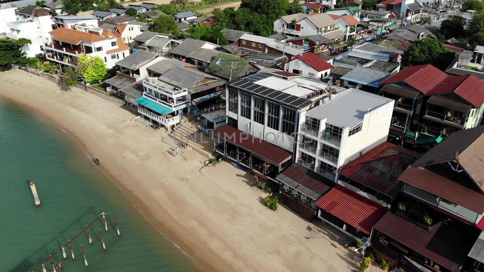 Fisherman village on seashore. Aerial view of typical touristic place on Ko Samui island with souvenir shops and walking street on sunny day. Architecture in asia, local settlement drone view by DogoraSun